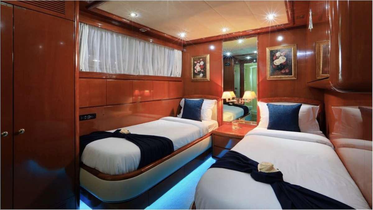 a room with beds and a mirror aboard DEMAREST Yacht for Charter