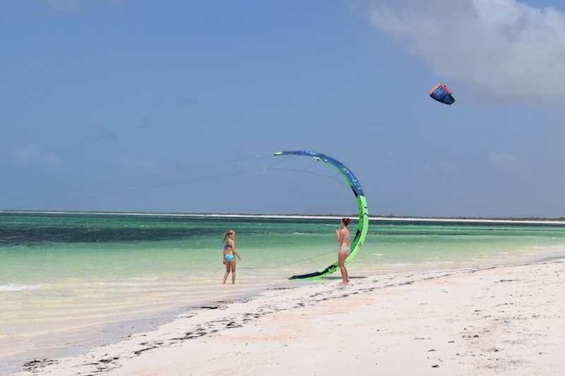 a couple of people flying a kite on a beach aboard HERO'S JOURNEY Yacht for Charter