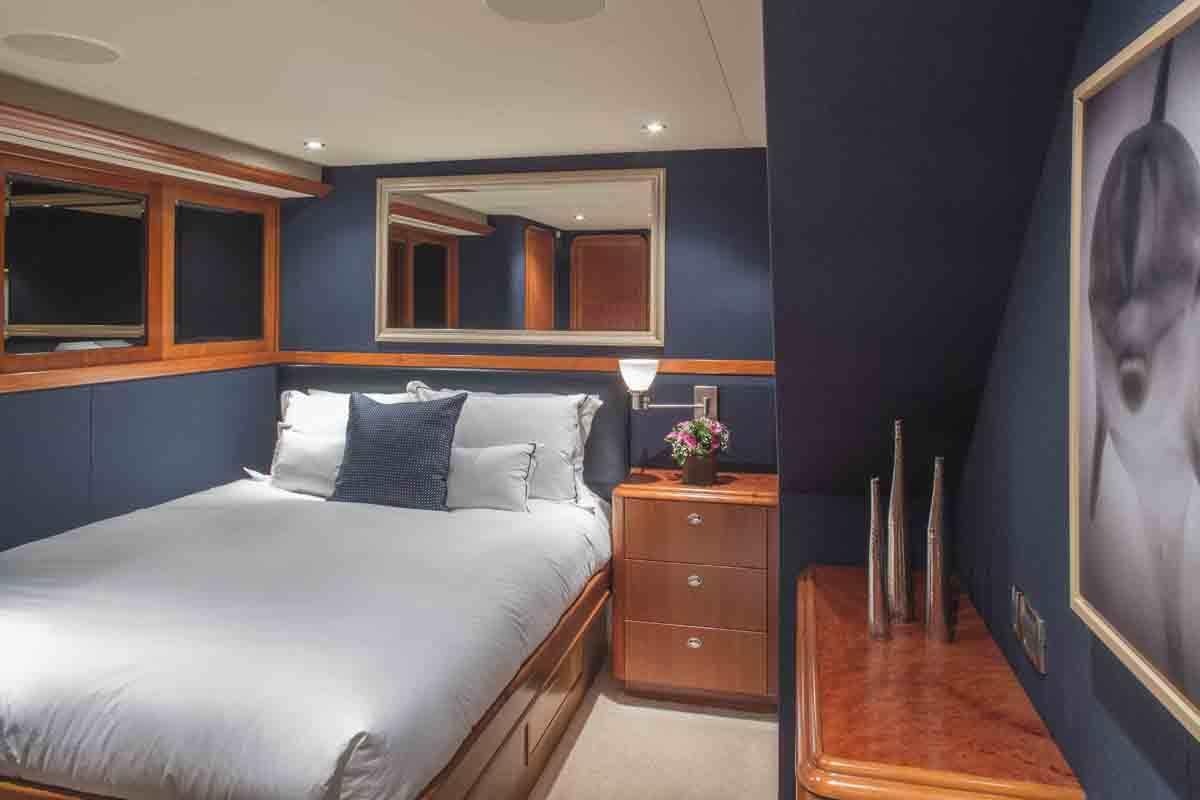 a bedroom with a blue wall aboard PLAN A Yacht for Charter