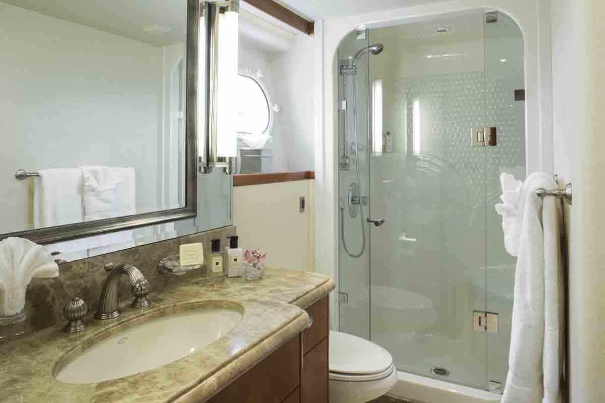 a bathroom with a glass shower door aboard PLAN A Yacht for Charter