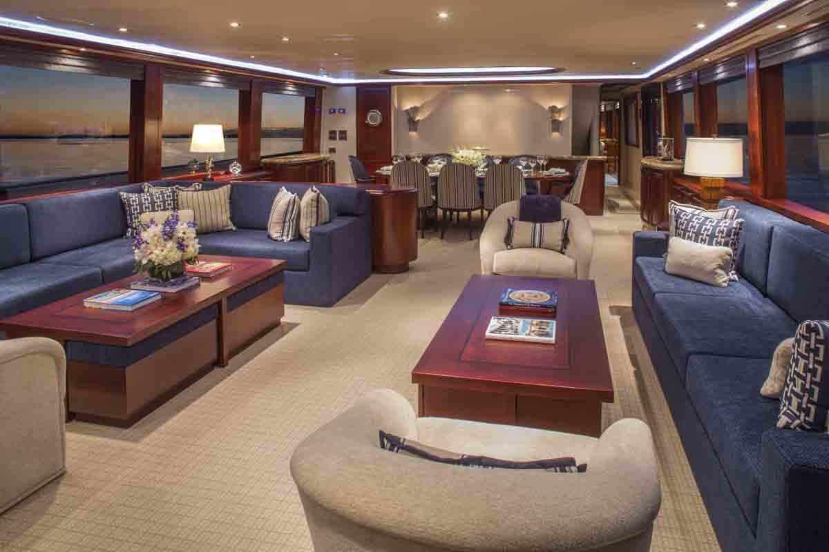 a living room with a blue couch and a coffee table aboard PLAN A Yacht for Charter