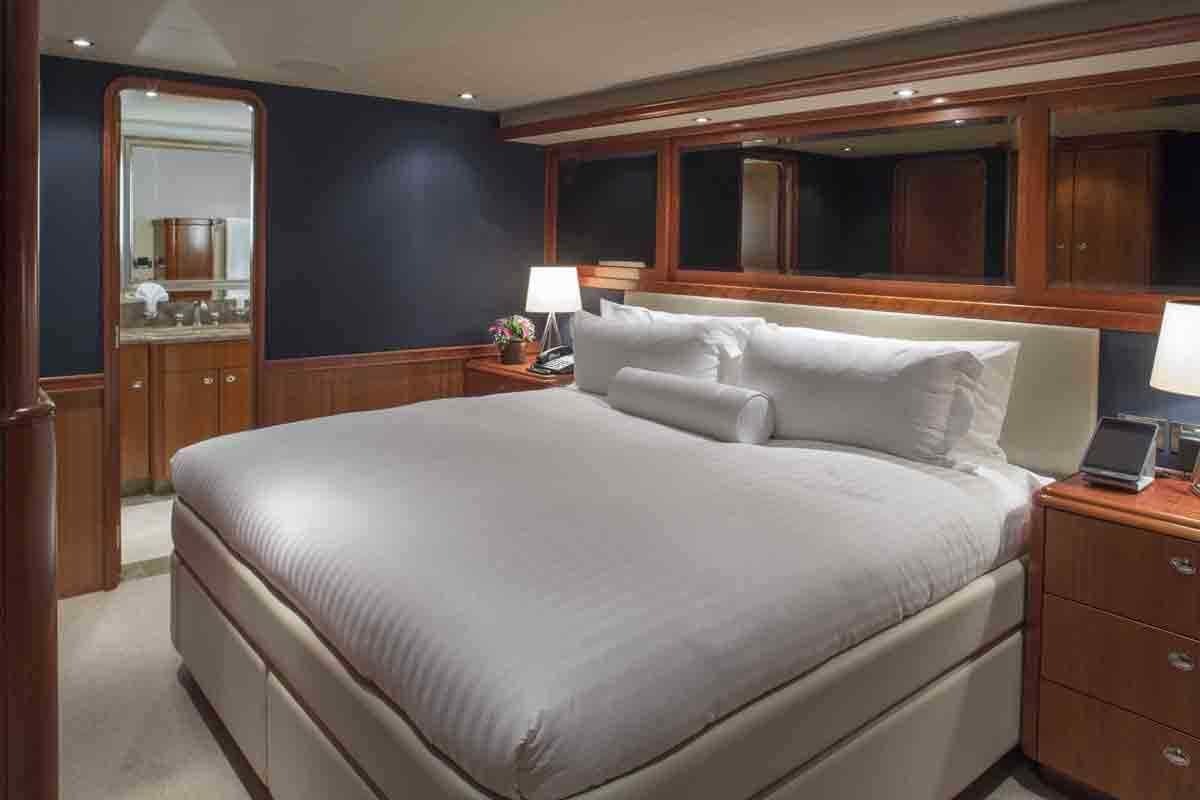 a bed with a white sheet aboard PLAN A Yacht for Charter