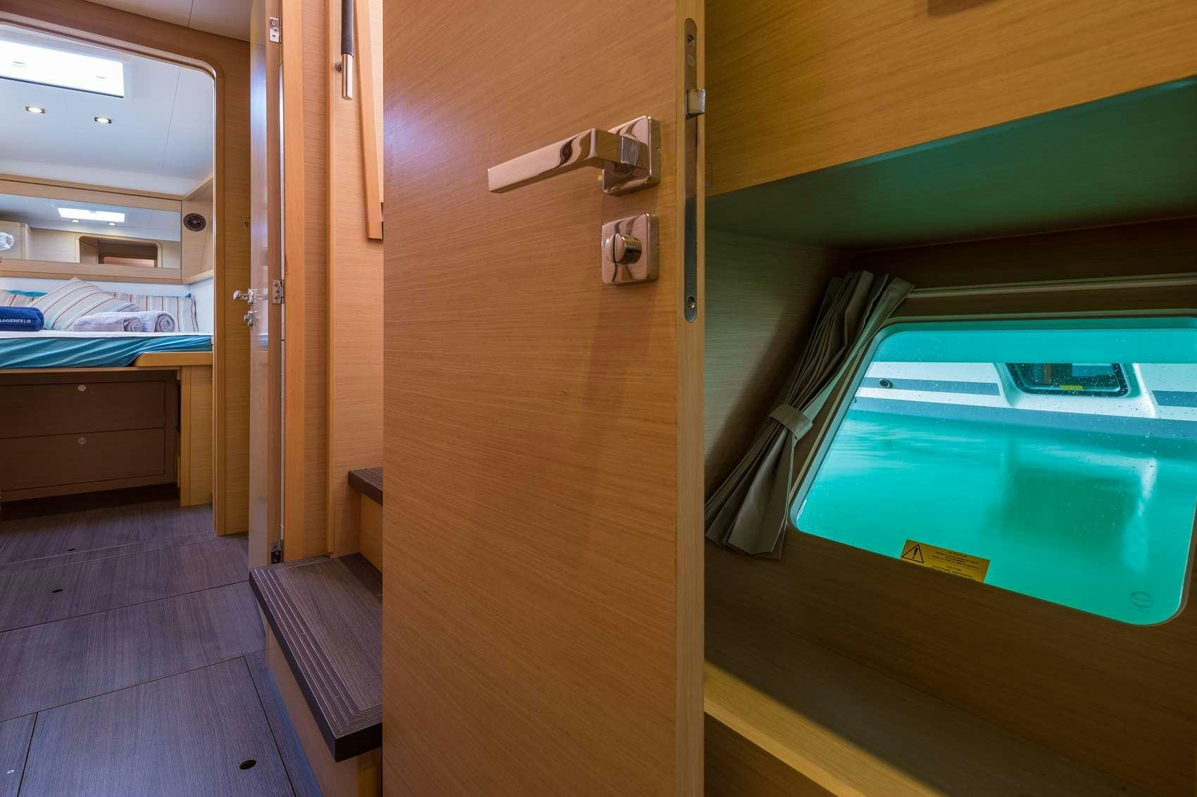 a room with a bed and a window aboard NEW HORIZONS Yacht for Charter