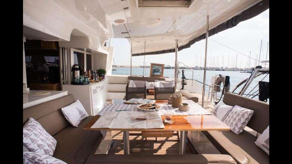 a table with a couch and a chair on it aboard NEW HORIZONS Yacht for Charter