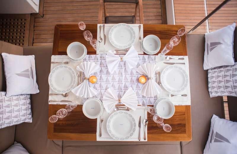 a table with plates and plates aboard NEW HORIZONS Yacht for Charter