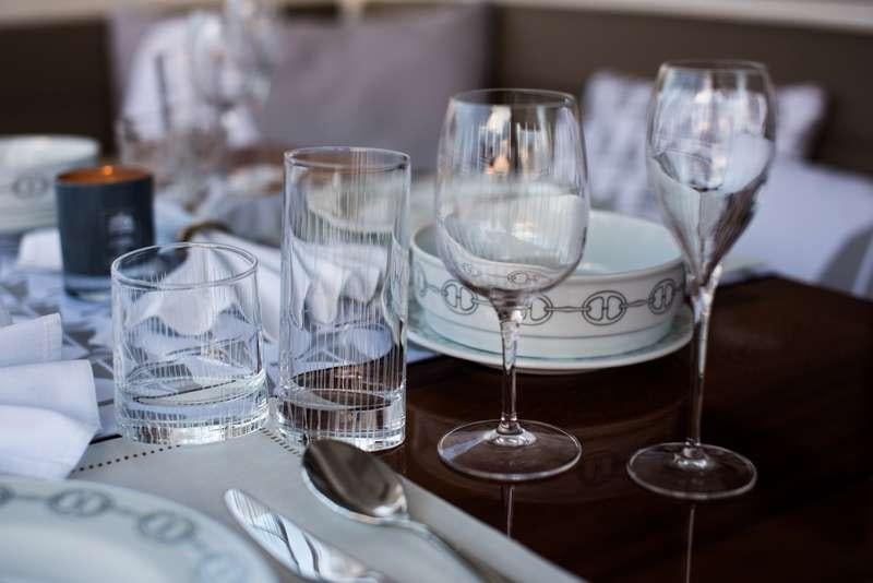a table with glasses and plates aboard NEW HORIZONS Yacht for Charter