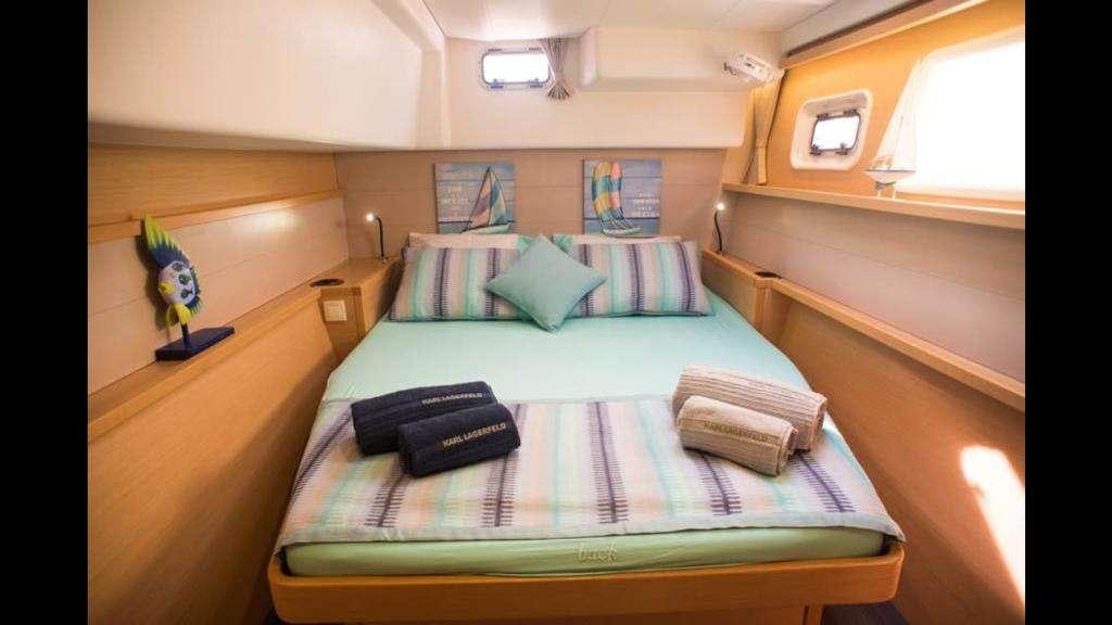 a bed with a blue sheet and pillows on it aboard NEW HORIZONS Yacht for Charter
