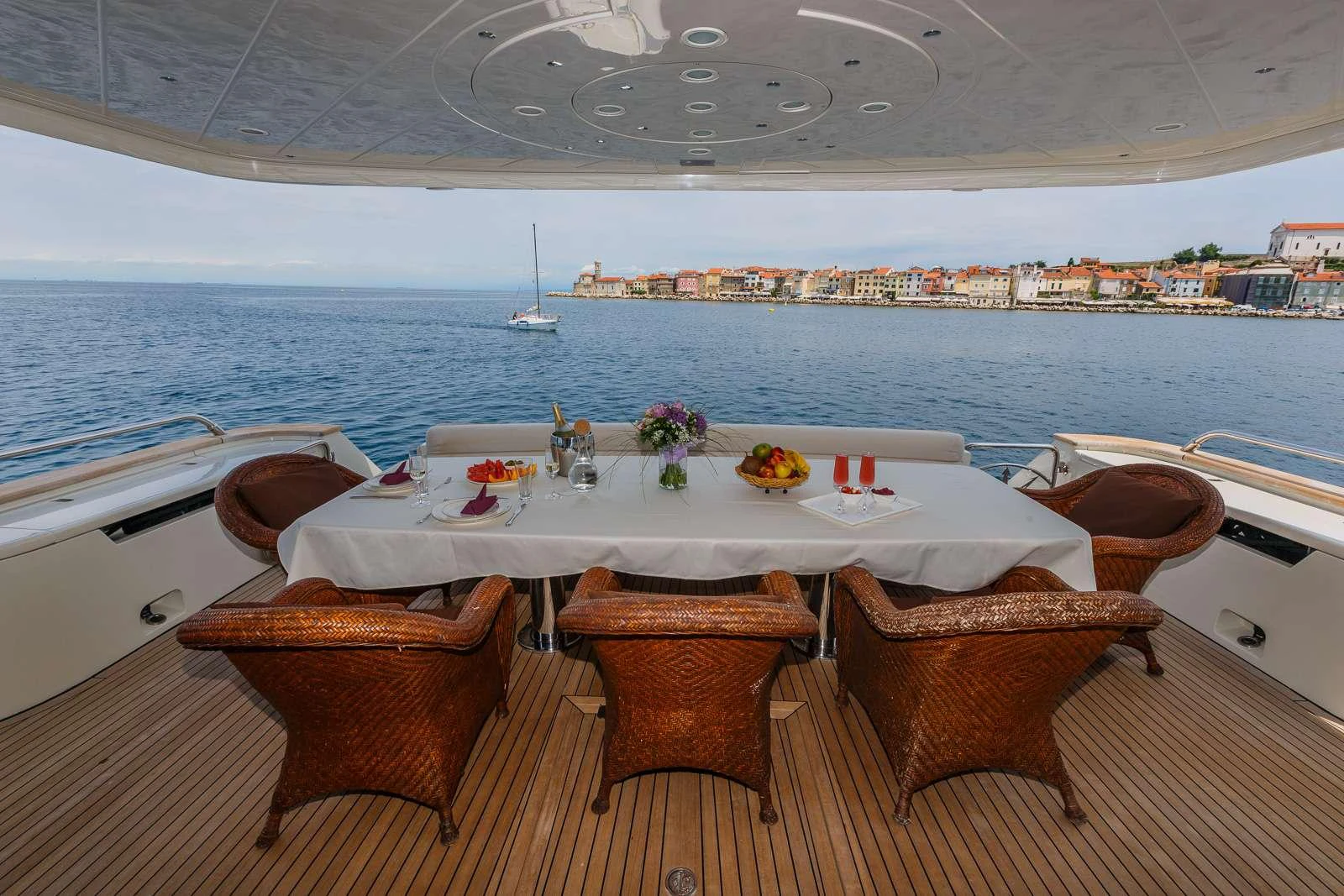 a table with chairs on it by a large body of water aboard VELLMARI Yacht for Charter