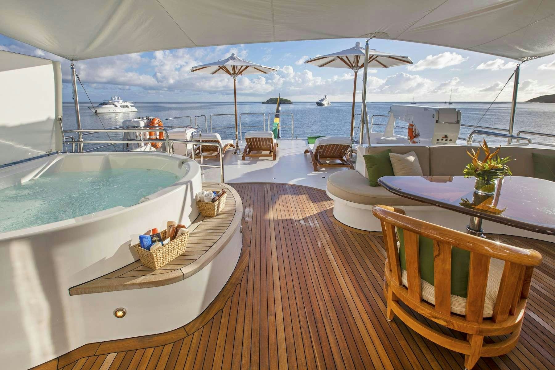 a large white tent with a table and chairs and umbrellas aboard ANTARES Yacht for Charter