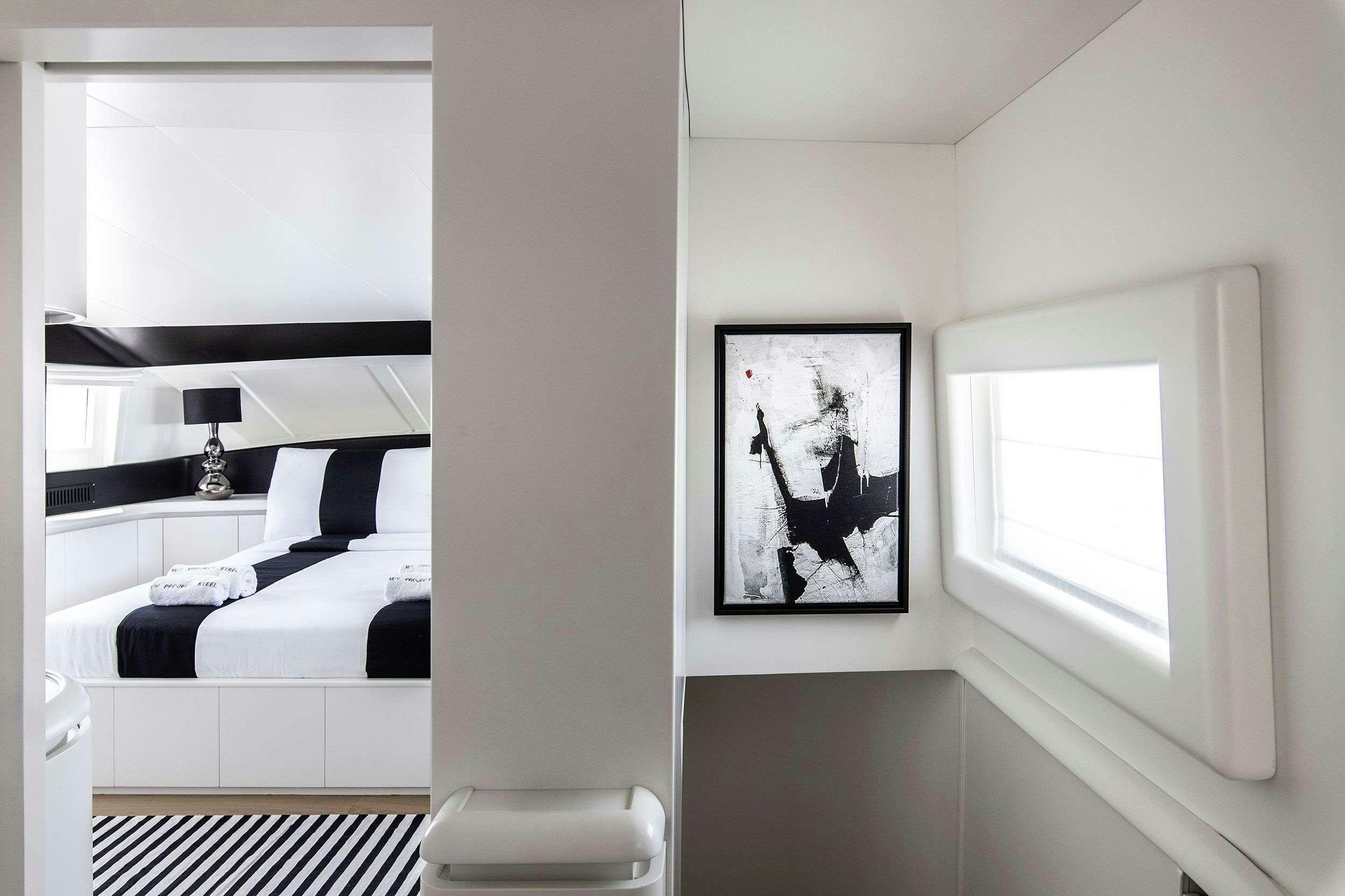 a room with a bed and a picture on the wall aboard PROJECT STEEL Yacht for Charter