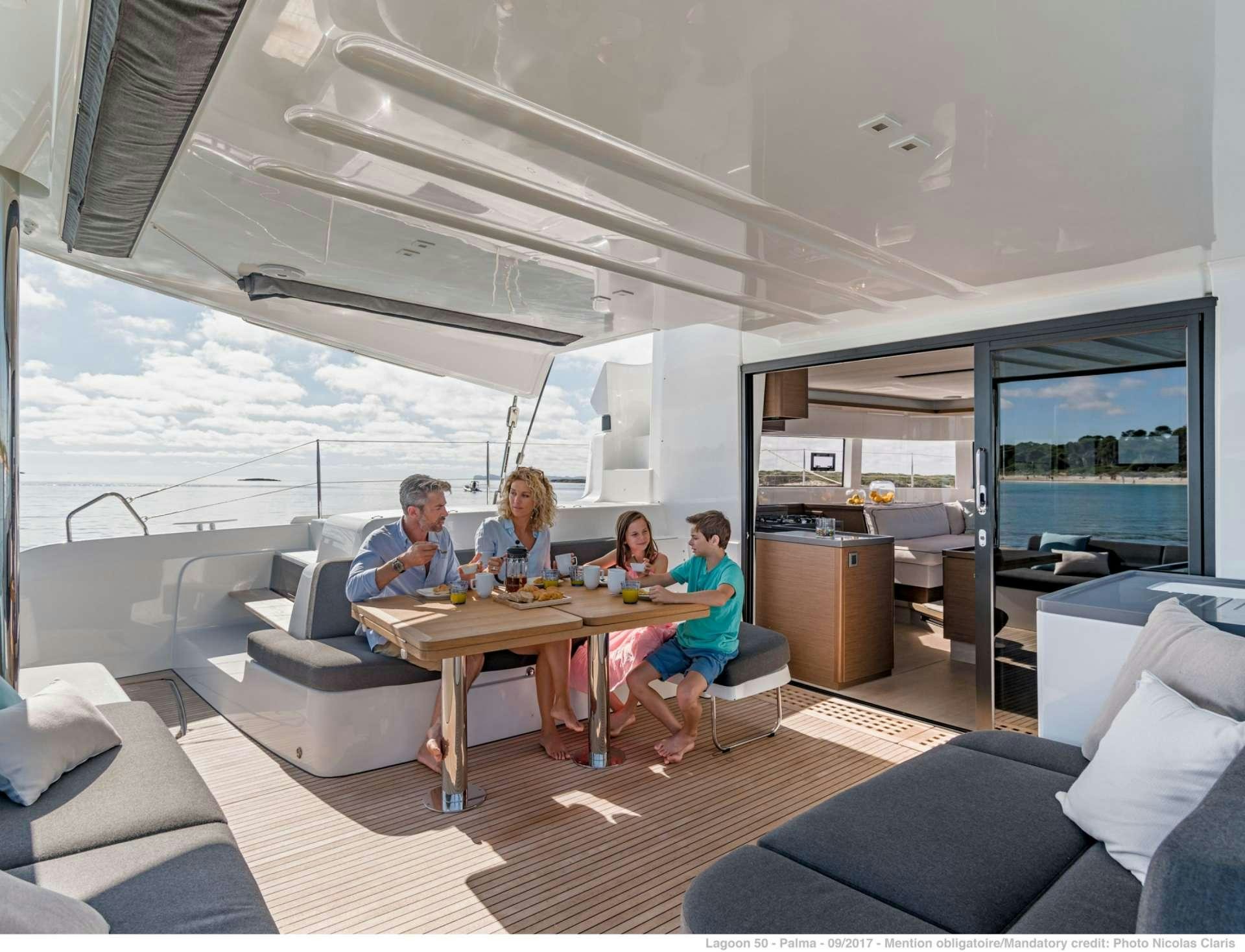 a group of people sitting around a table in a room aboard HAPPY FEET Yacht for Charter