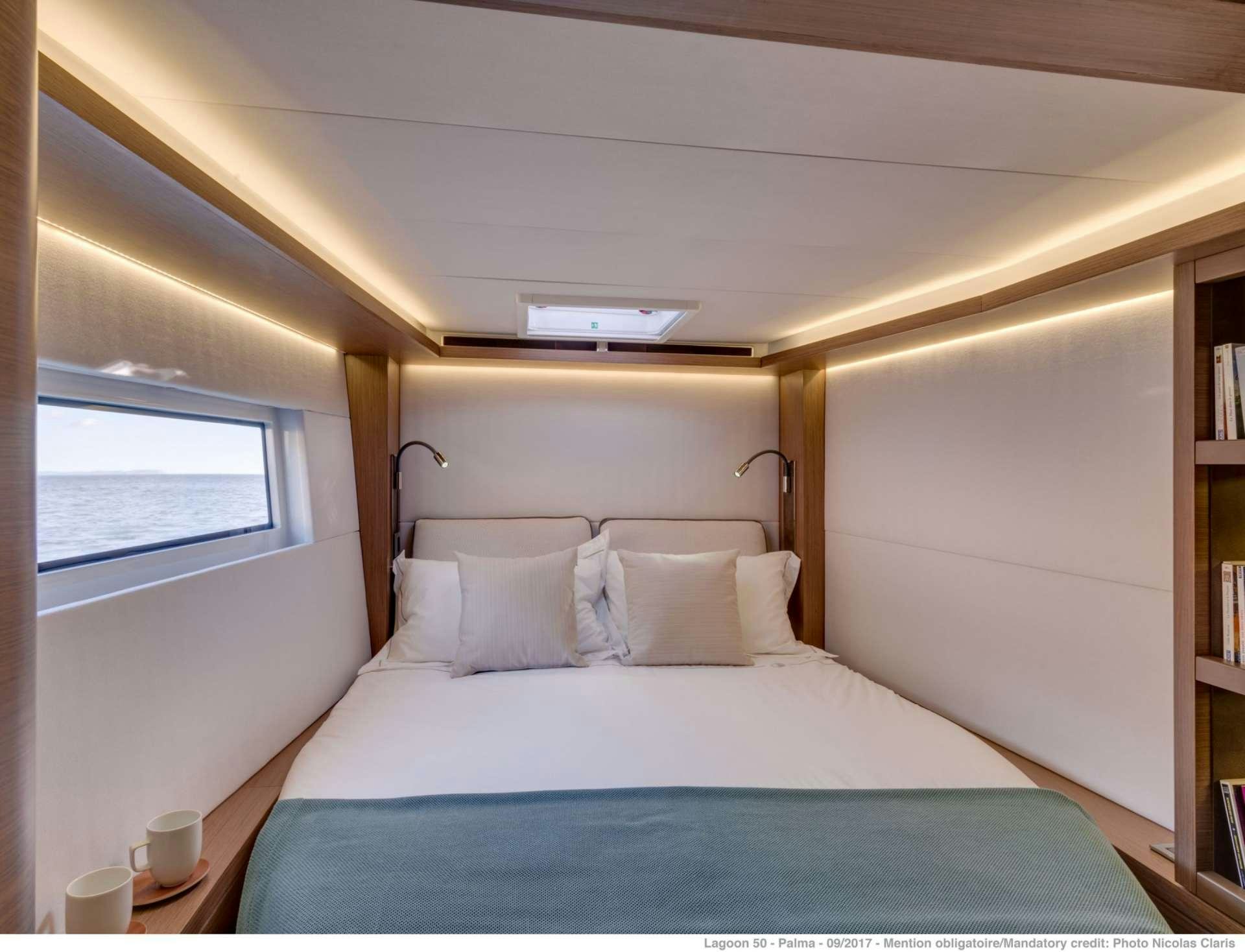 a bed with a blue sheet aboard HAPPY FEET Yacht for Charter