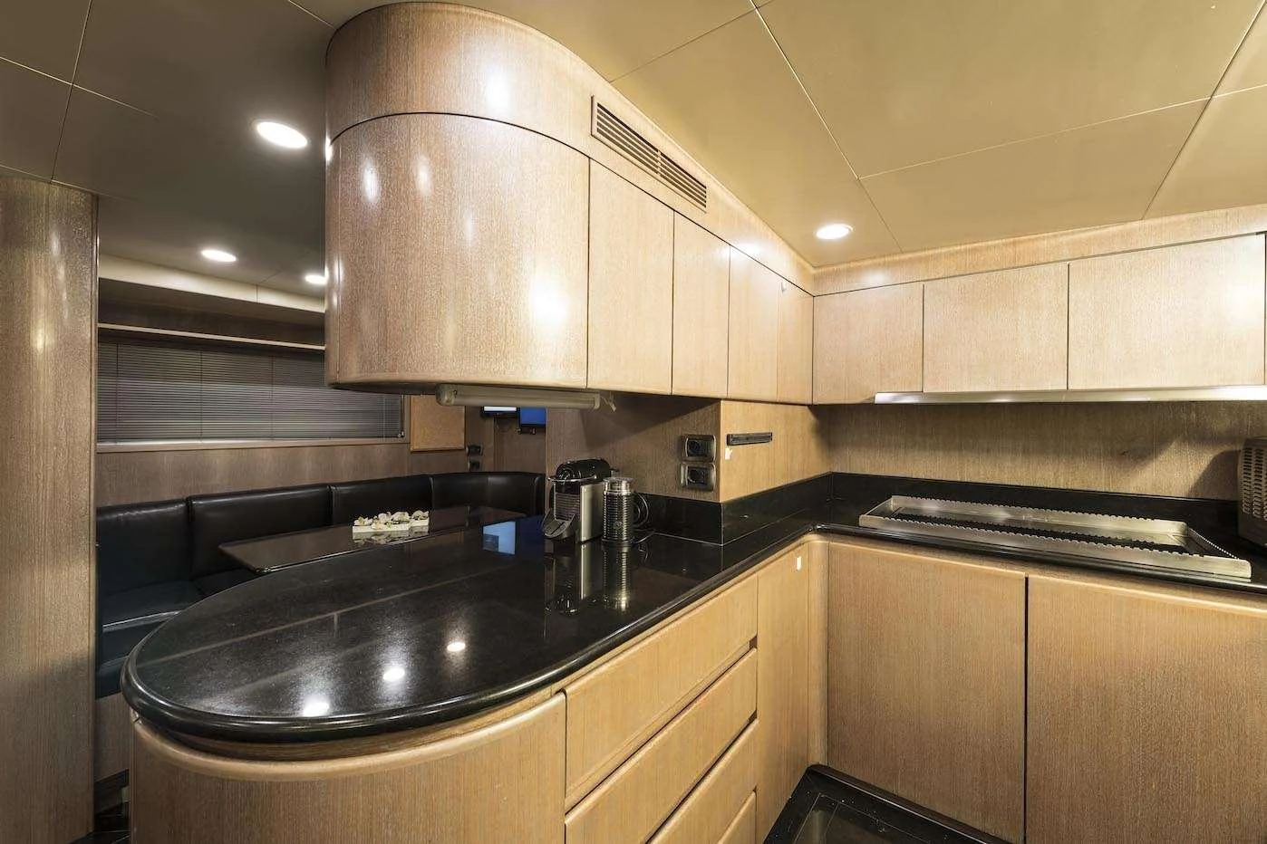 The yacht's galley features sleek wooden cabinetry and modern appliances, creating a sophisticated culinary space. aboard KALIMERA Yacht for Charter