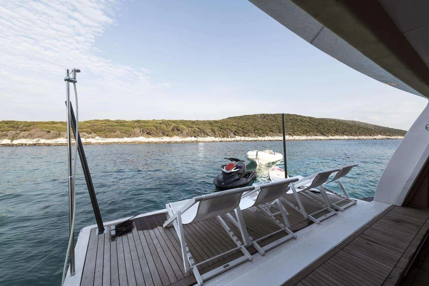 The yacht's swim platform offers a relaxing space with lounge chairs and easy access to the water. aboard KALIMERA Yacht for Charter