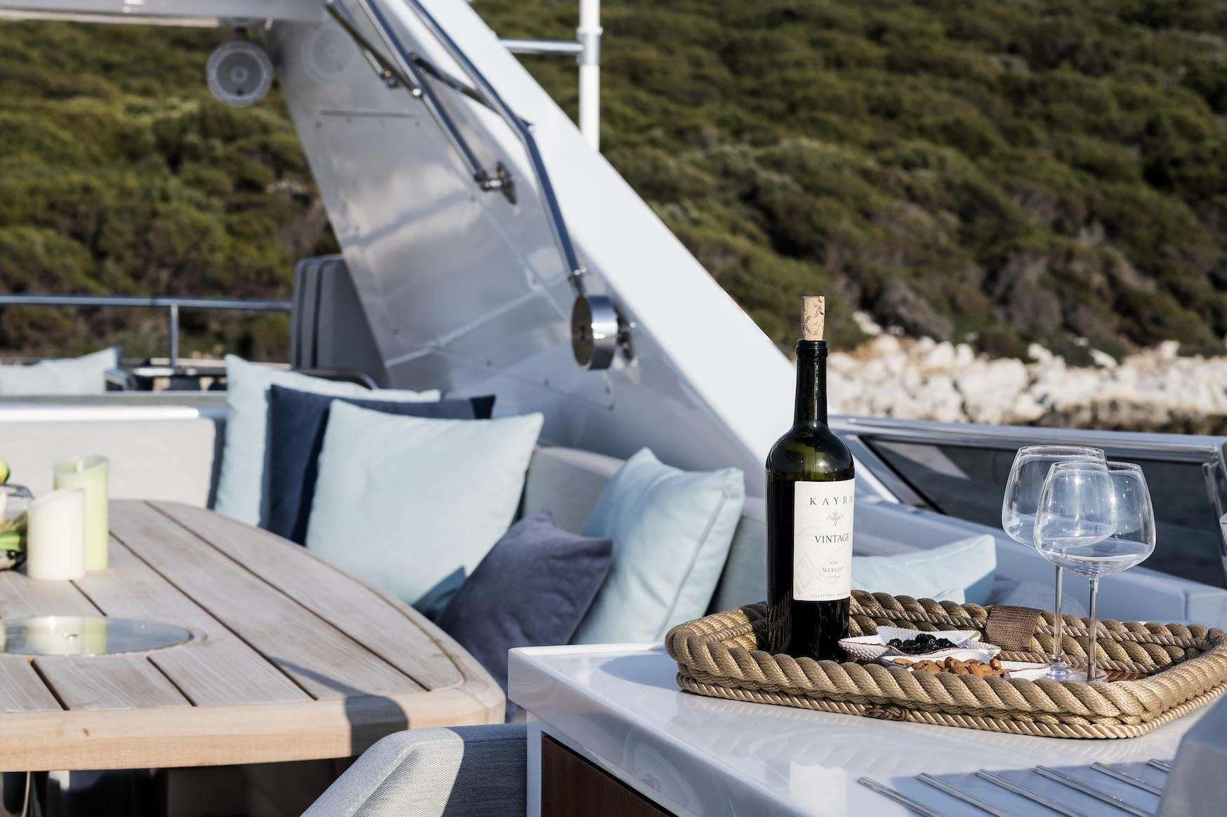 The aft deck offers a relaxing space with a table set for drinks and a scenic view. aboard KALIMERA Yacht for Charter