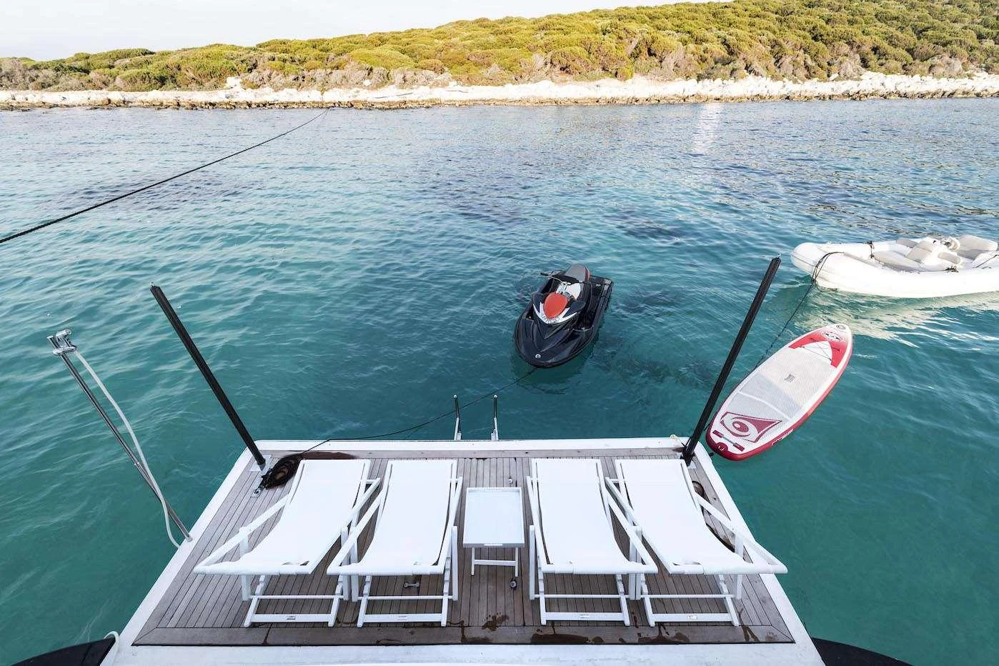 The yacht's swim platform offers a relaxing space with lounge chairs and easy access to water toys. aboard KALIMERA Yacht for Charter