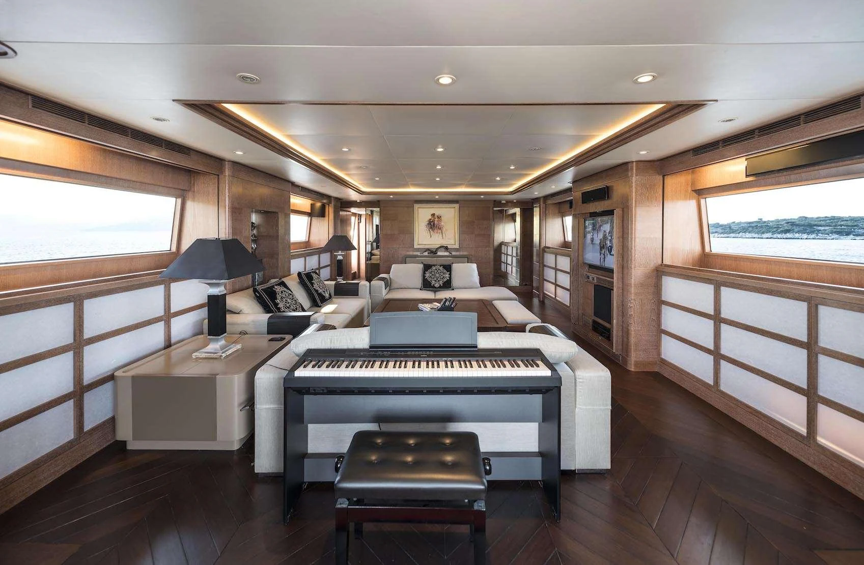 The yacht's salon features elegant furnishings and a piano, offering a luxurious and inviting atmosphere. aboard KALIMERA Yacht for Charter