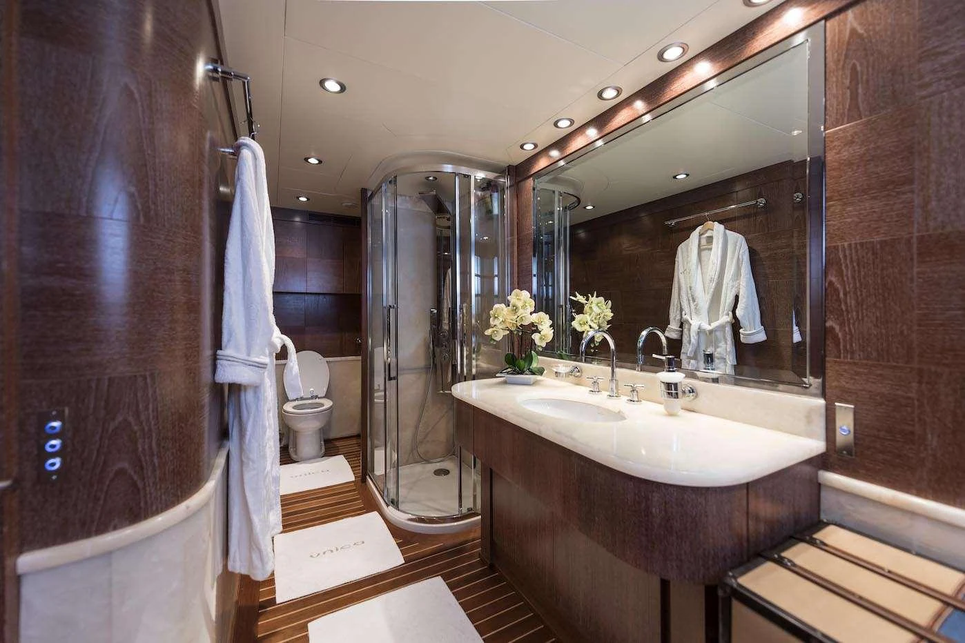 The yacht's bathroom features elegant wood paneling, a spacious shower, and luxurious fixtures. aboard KALIMERA Yacht for Charter