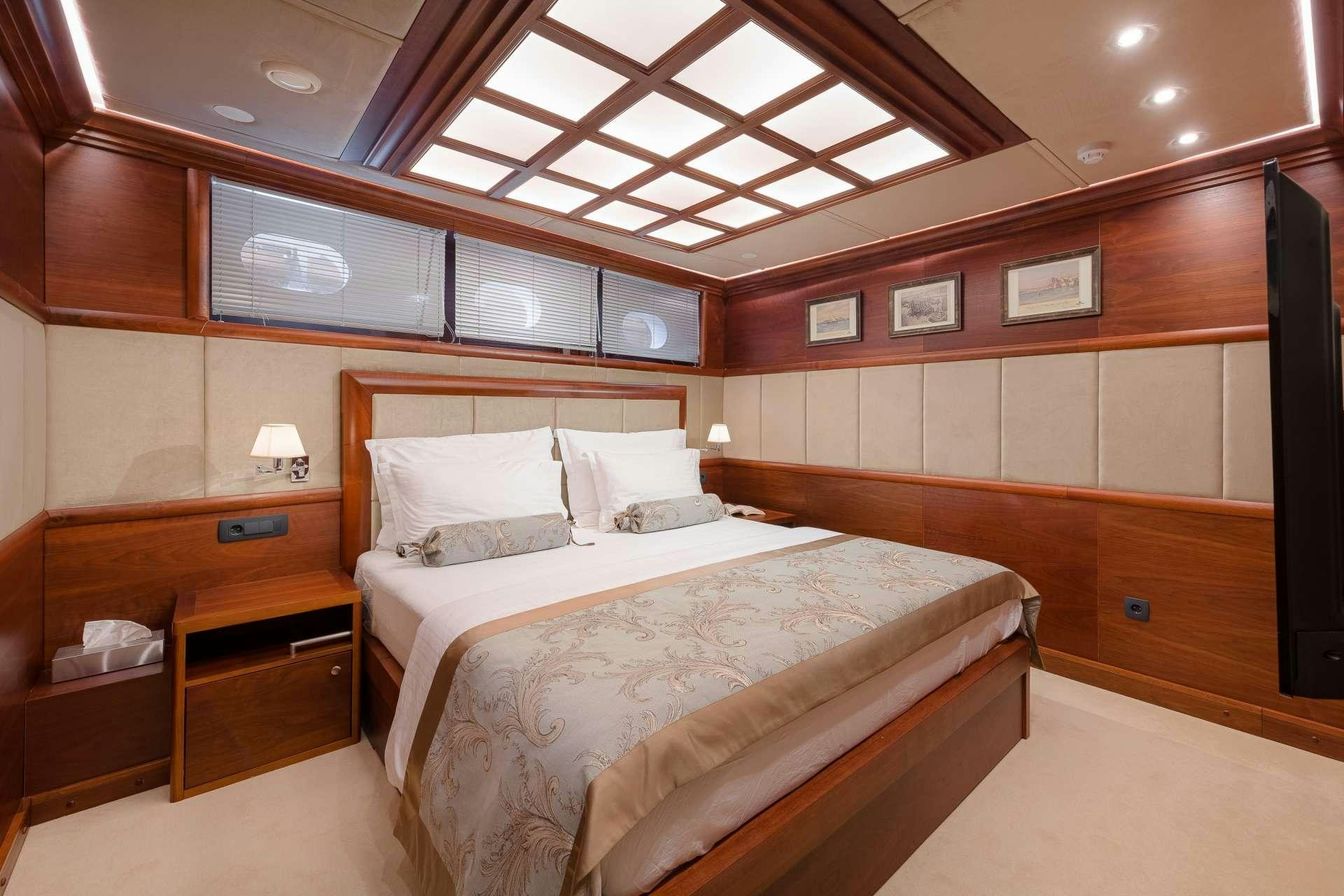 a room with a bed and a desk aboard LADY GITA Yacht for Charter