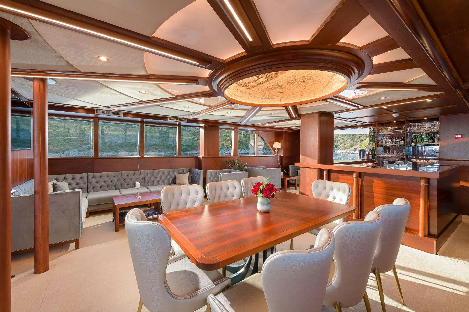 a room with a table chairs and a large window aboard LADY GITA Yacht for Charter