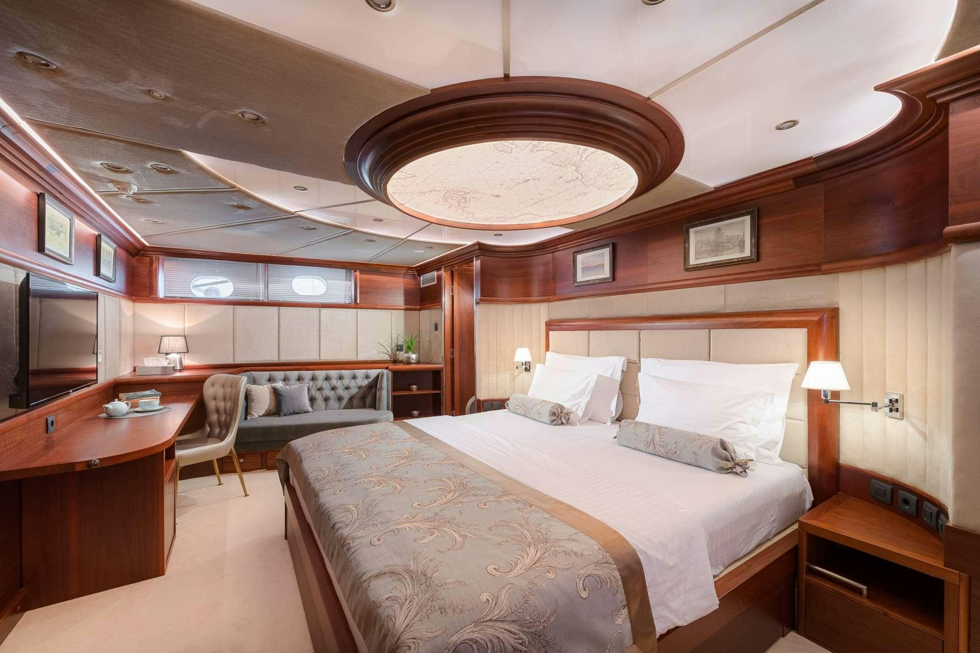 a hotel room with a bed and desk aboard LADY GITA Yacht for Charter