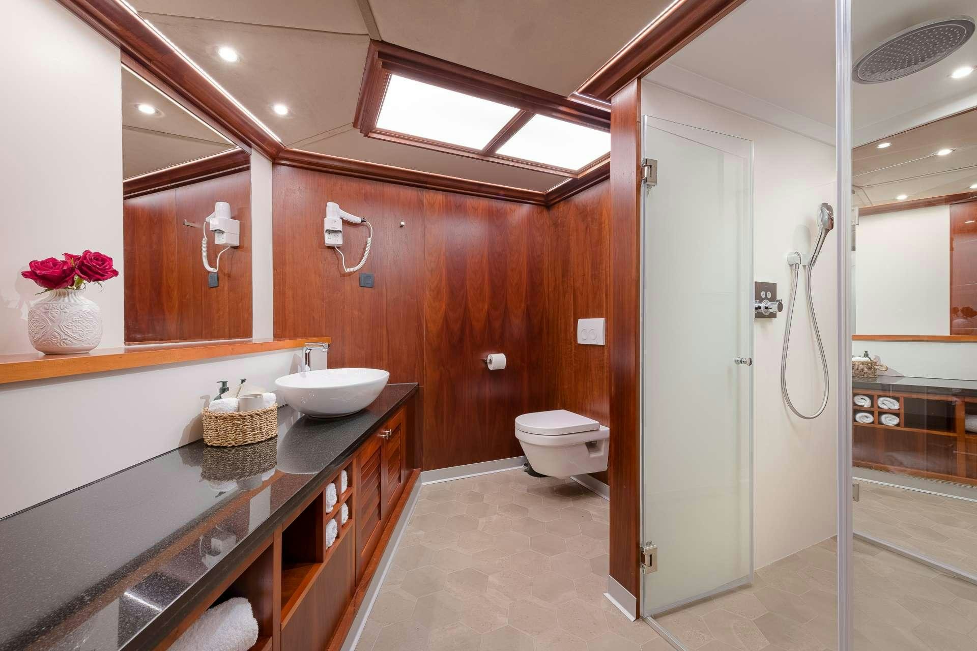 a bathroom with a countertop sink and a toilet aboard LADY GITA Yacht for Charter