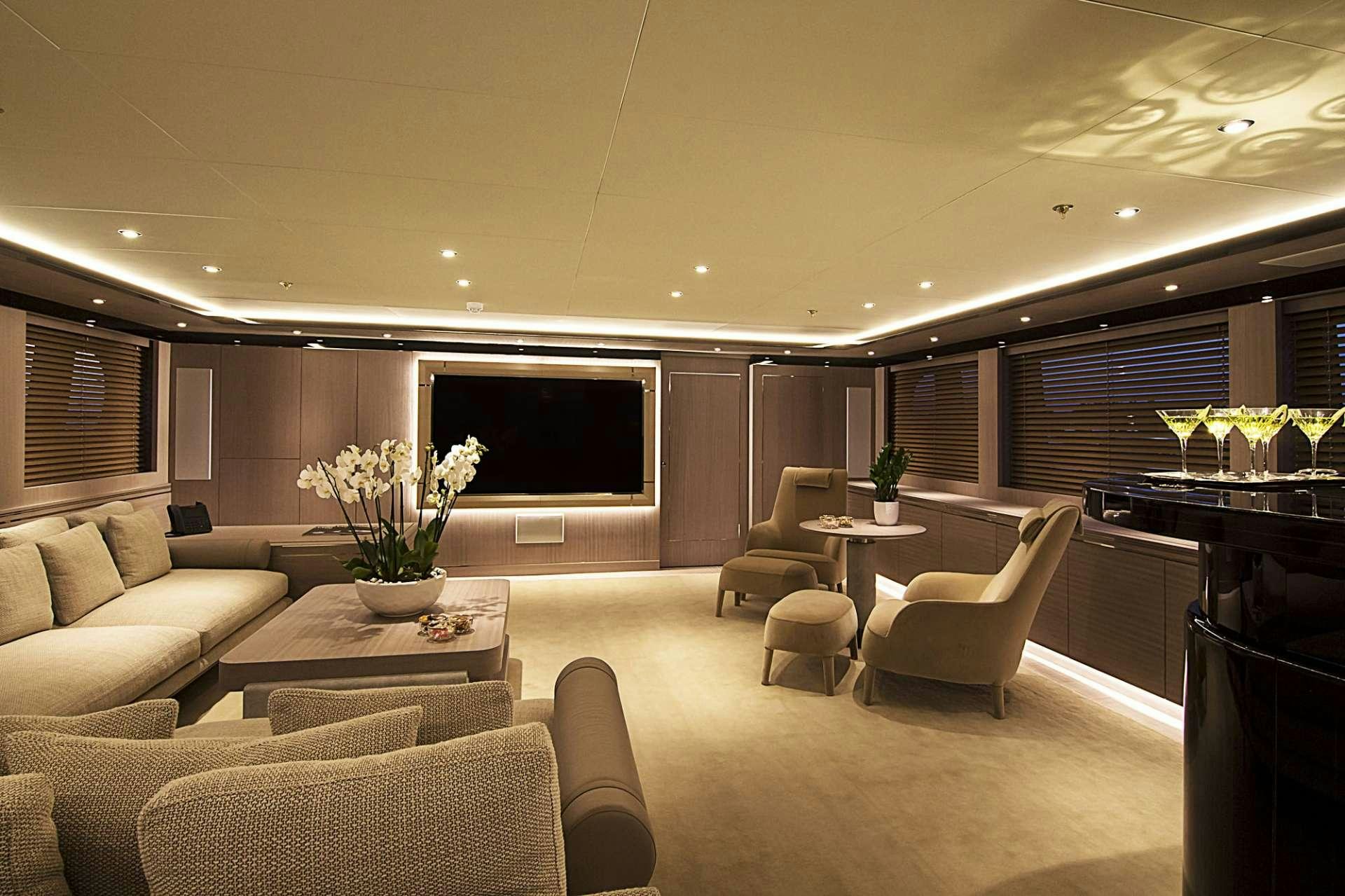 a room with a table chairs and a tv aboard INVADER Yacht for Charter