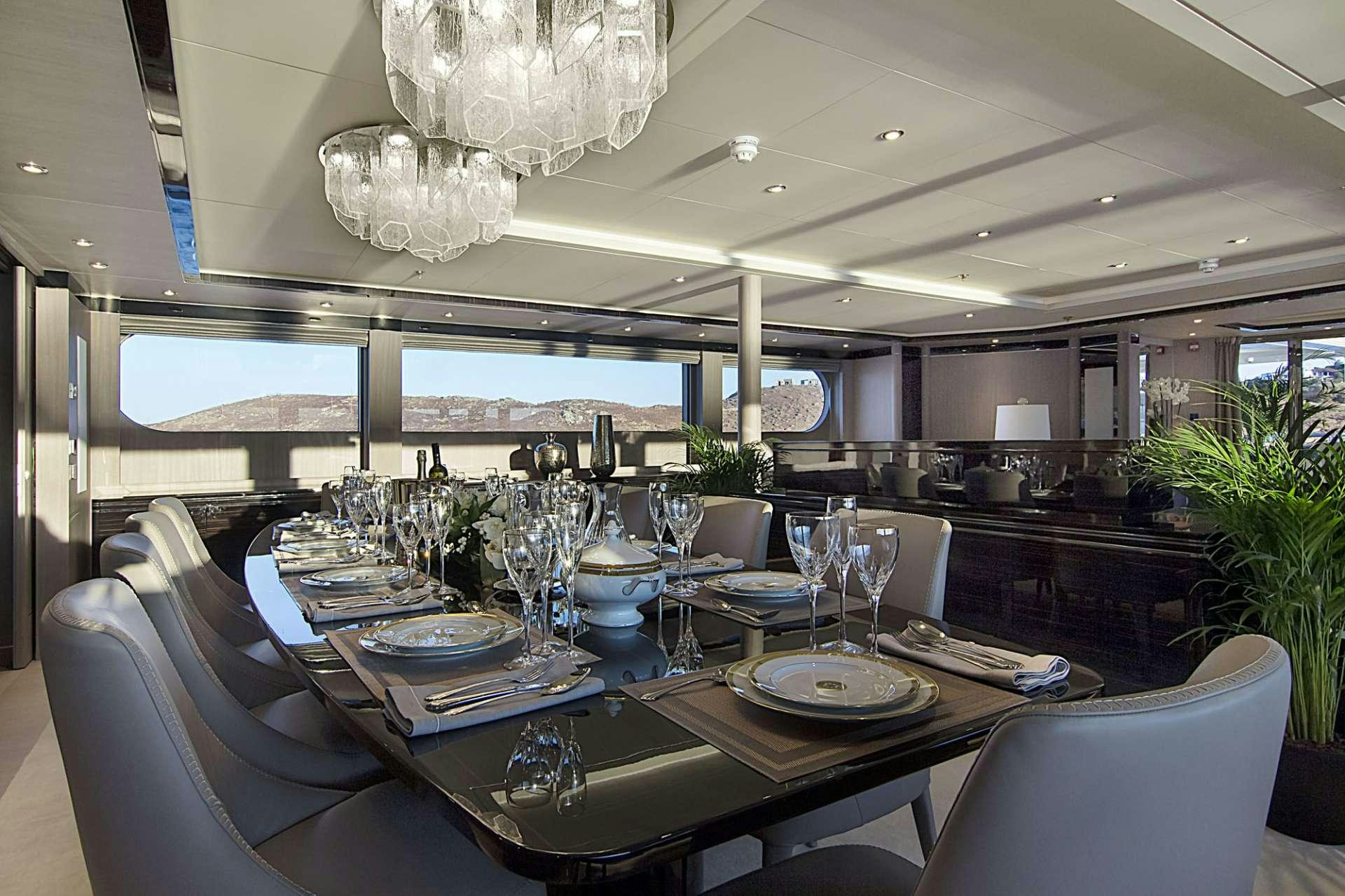 a dining room with a chandelier aboard INVADER Yacht for Charter