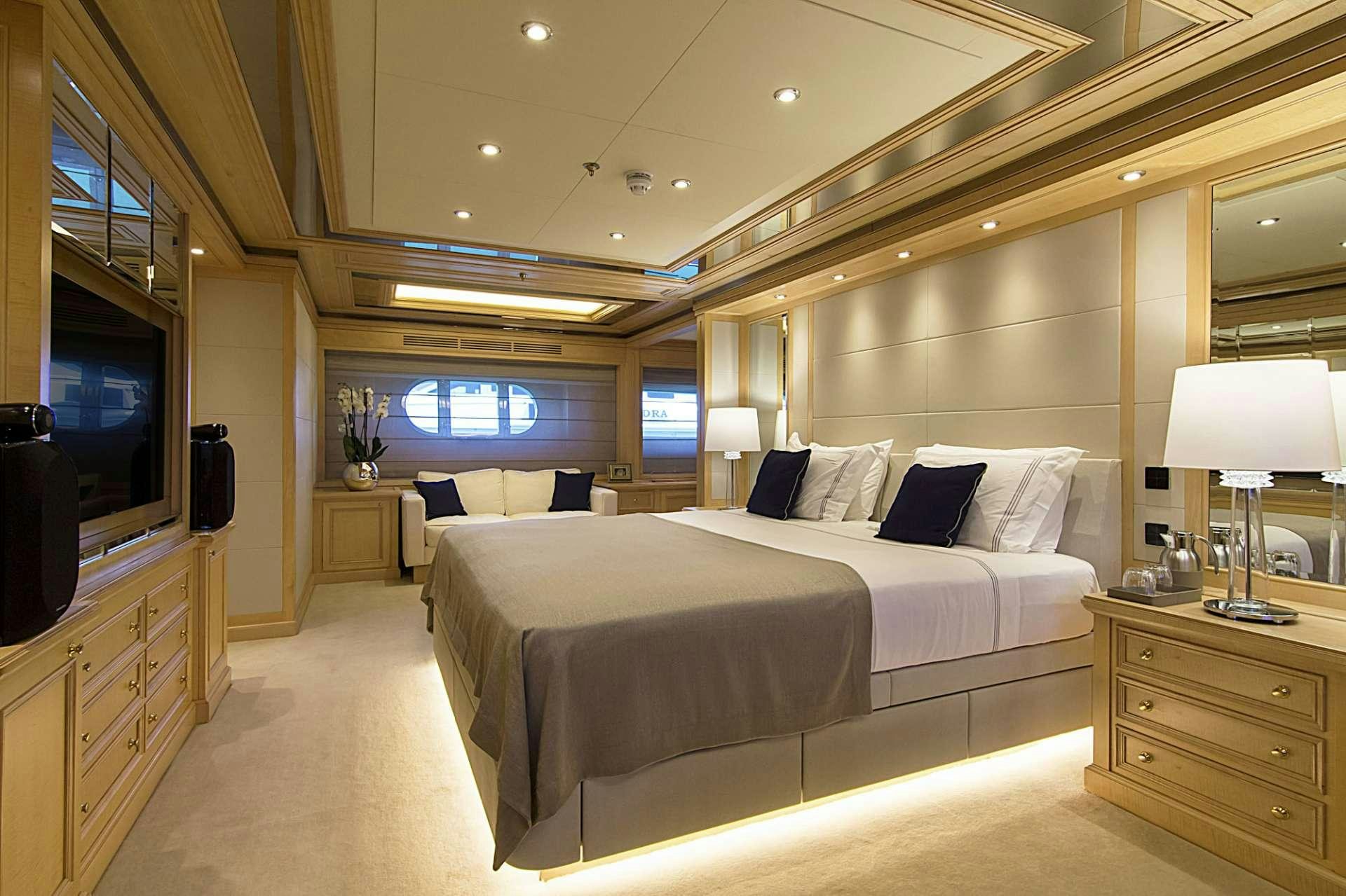 a room with a bed and a television aboard INVADER Yacht for Charter