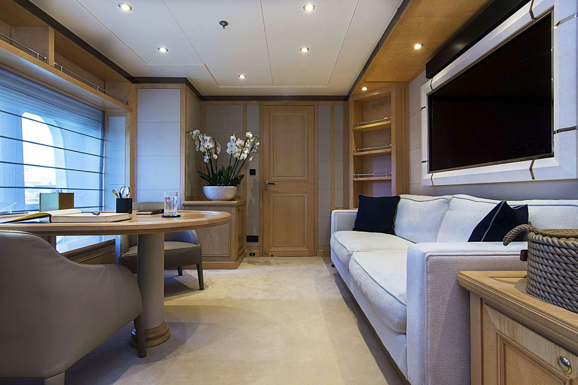 a living room with a couch and a television aboard INVADER Yacht for Charter