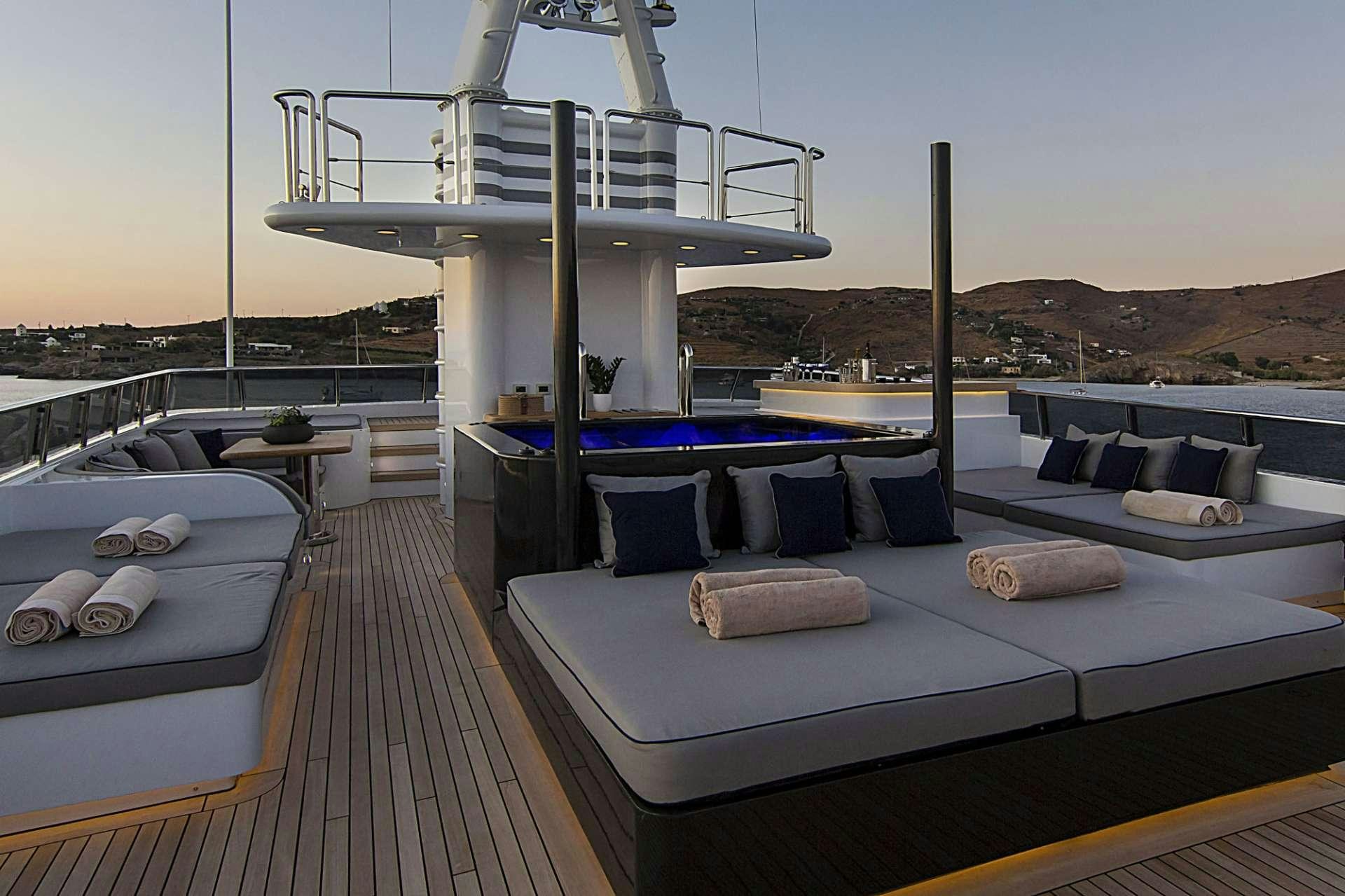 a deck with a pool and a deck with a view of mountains aboard INVADER Yacht for Charter
