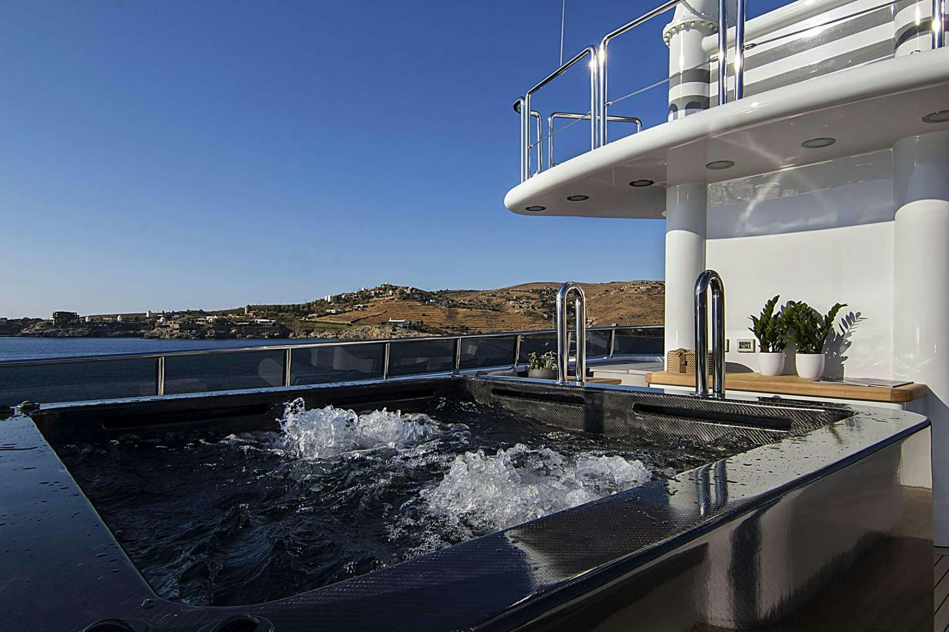 a large outdoor pool with a large waterfall aboard INVADER Yacht for Charter