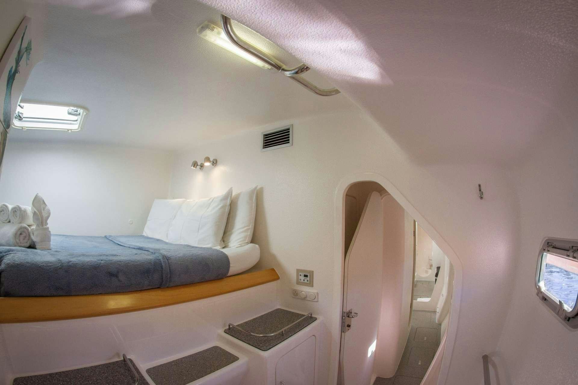 a bedroom with a bed and a television aboard VOYAGE 500 Yacht for Charter