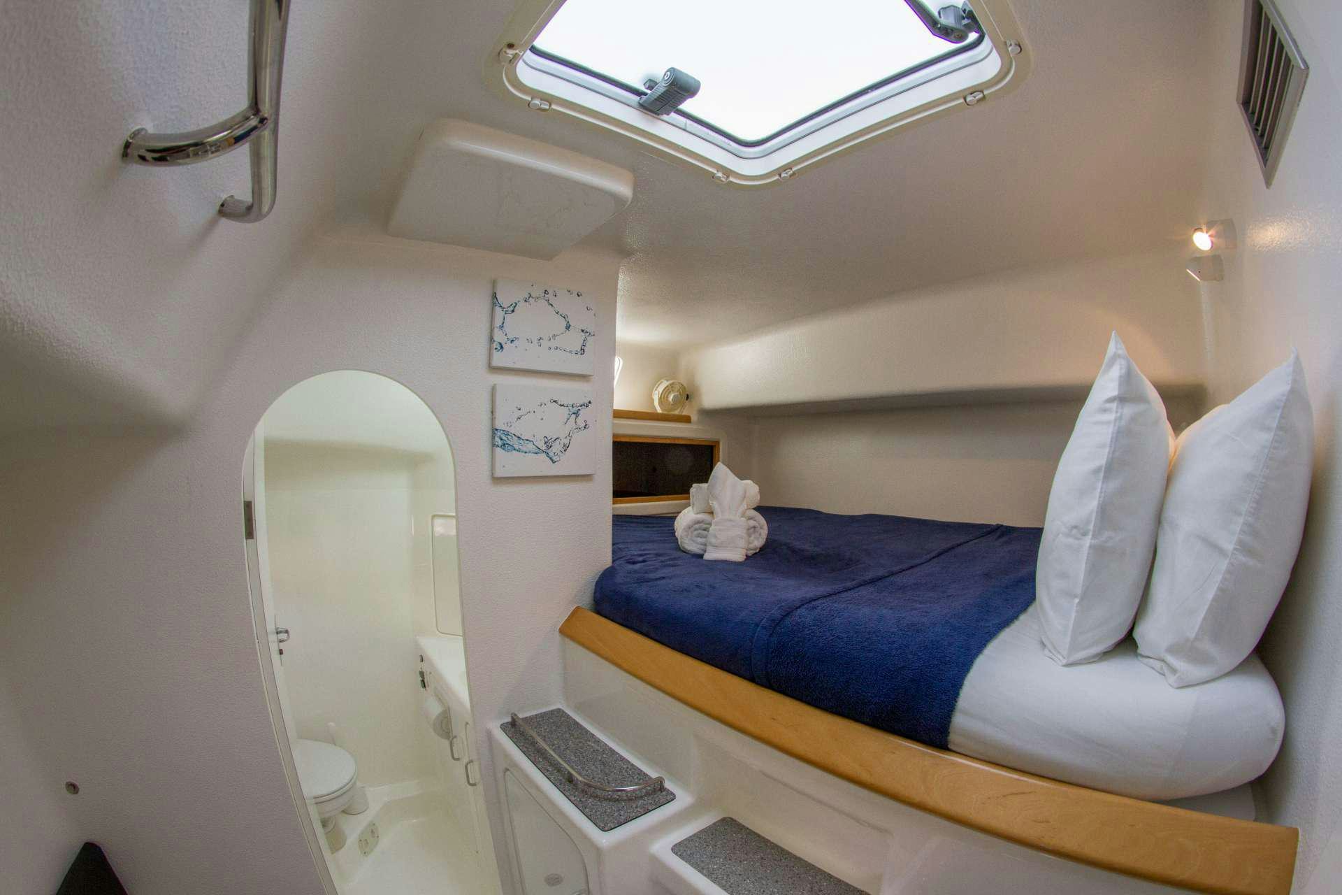 a bed with a blue sheet aboard VOYAGE 500 Yacht for Charter