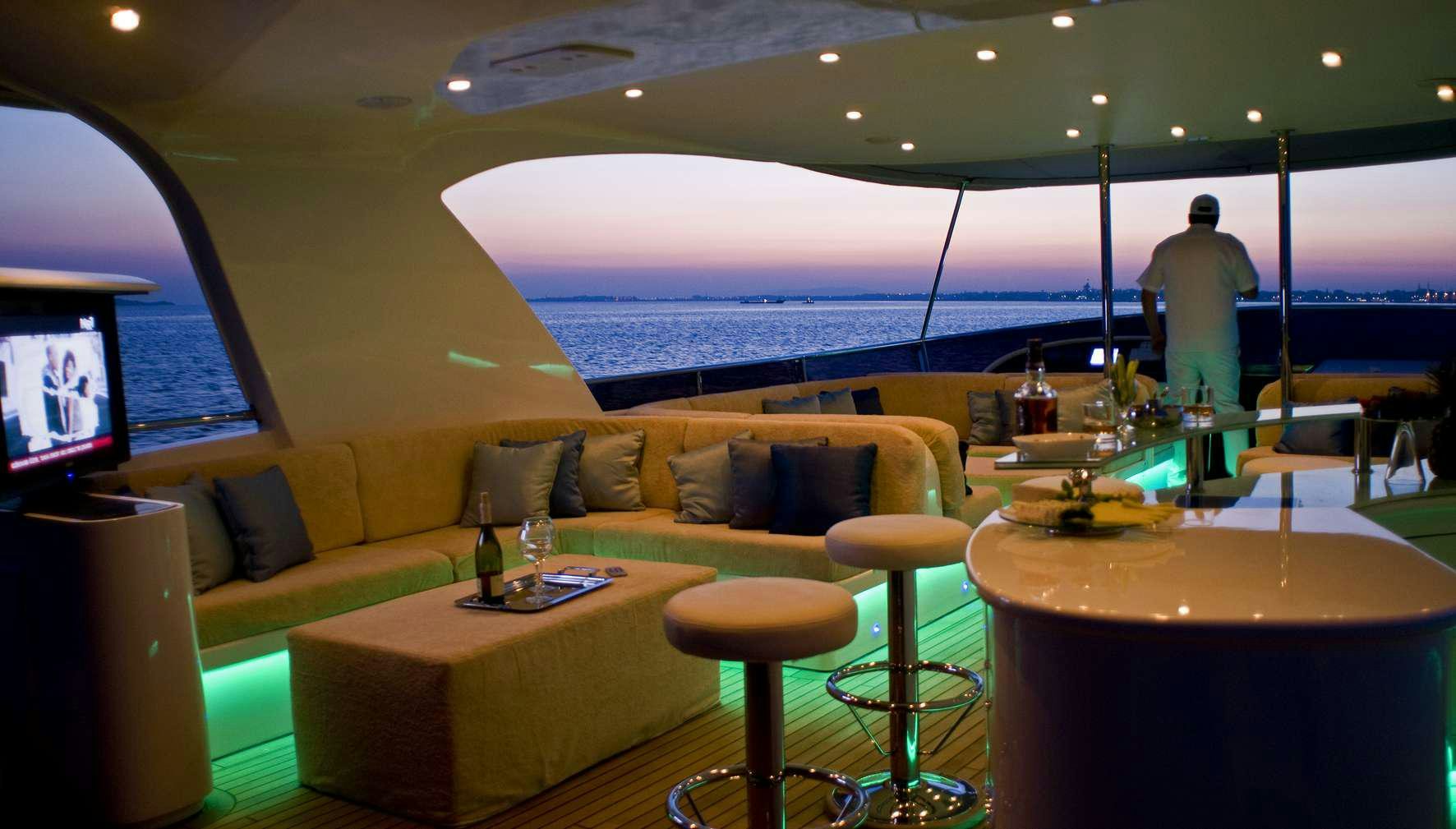 a room with a couch and a table and a television aboard AZMIM Yacht for Charter