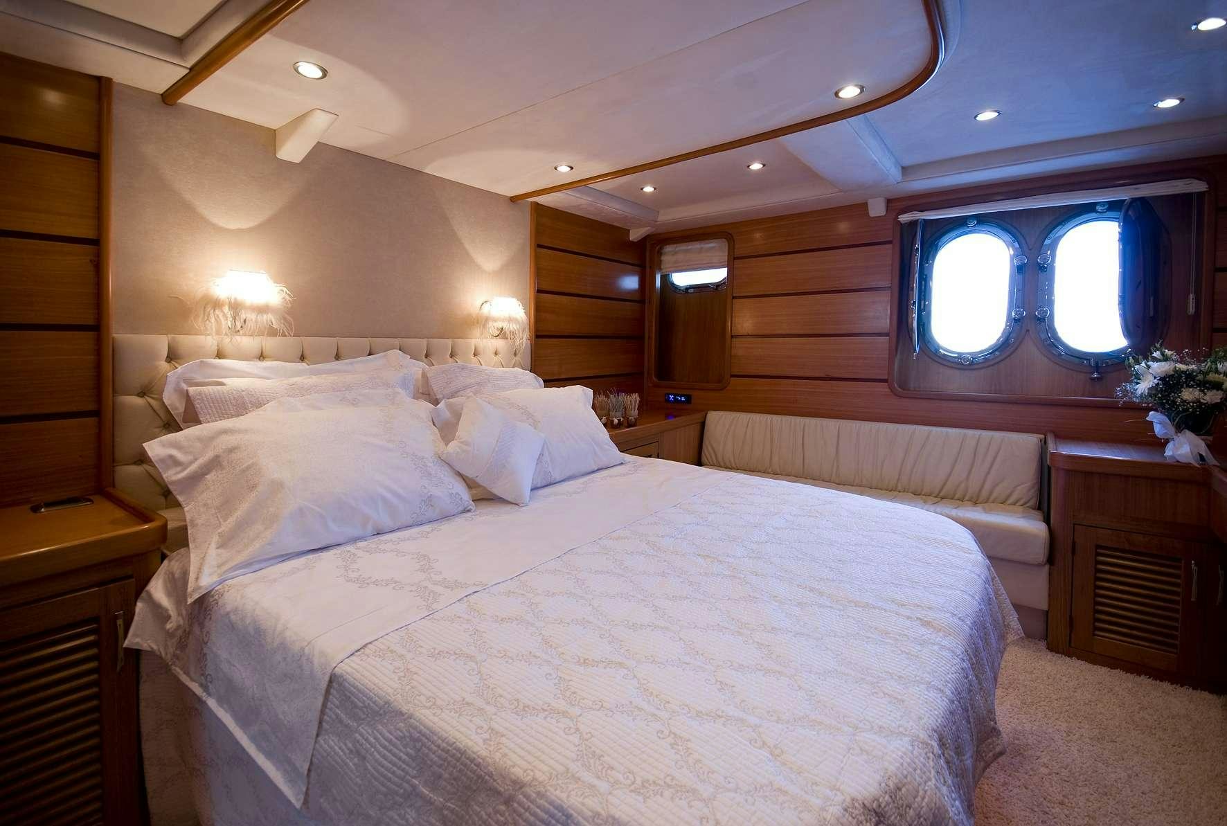 a large bed with white sheets aboard AZMIM Yacht for Charter