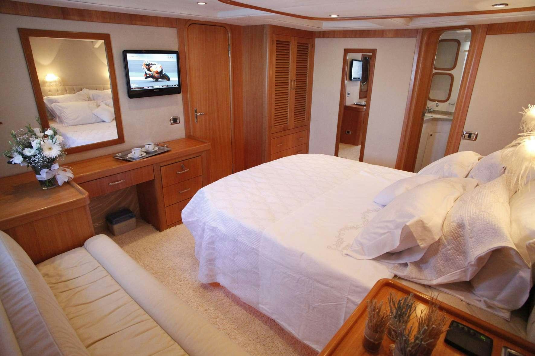 a hotel room with a bed and a television aboard AZMIM Yacht for Charter