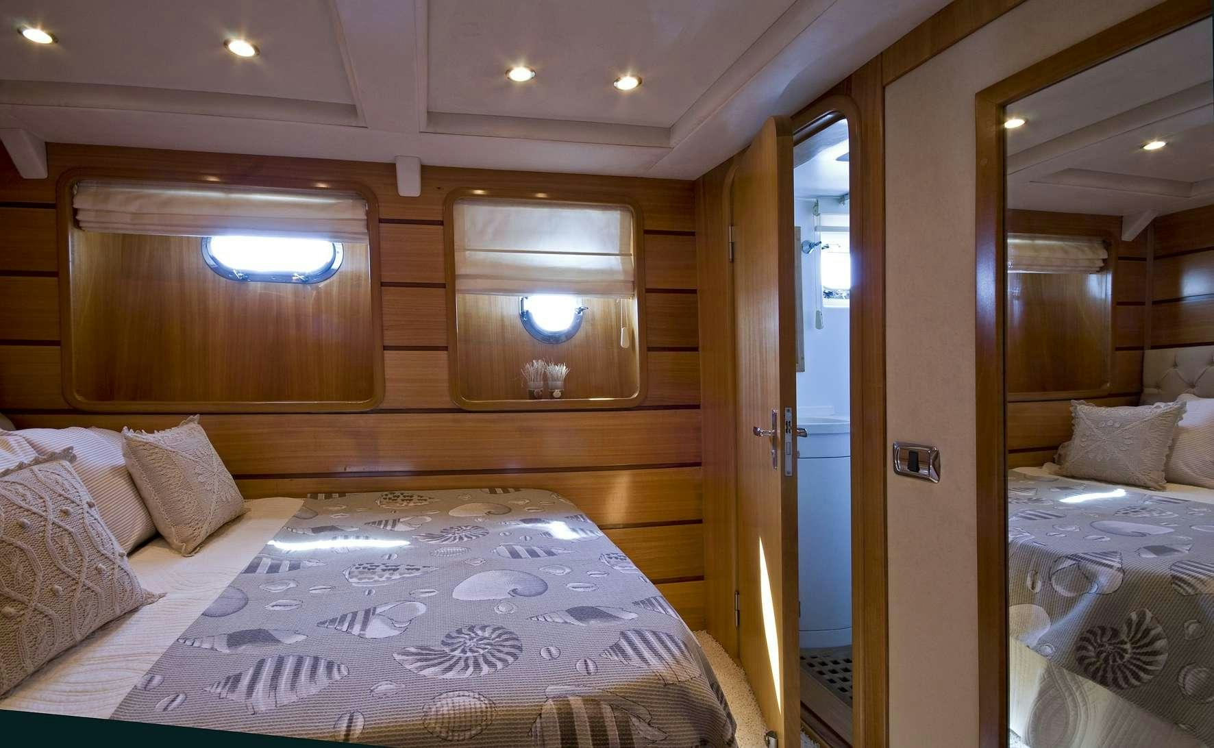 a room with a bed and a mirror aboard AZMIM Yacht for Charter