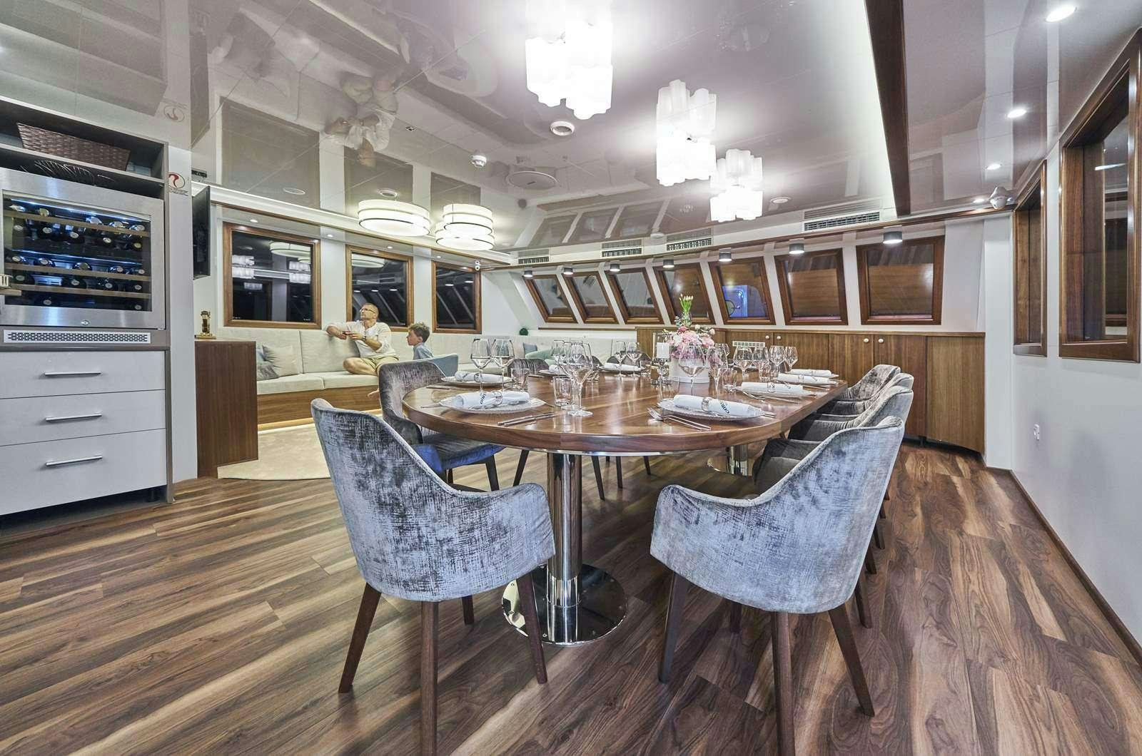 a kitchen with a dining table and chairs aboard CORSARIO Yacht for Charter
