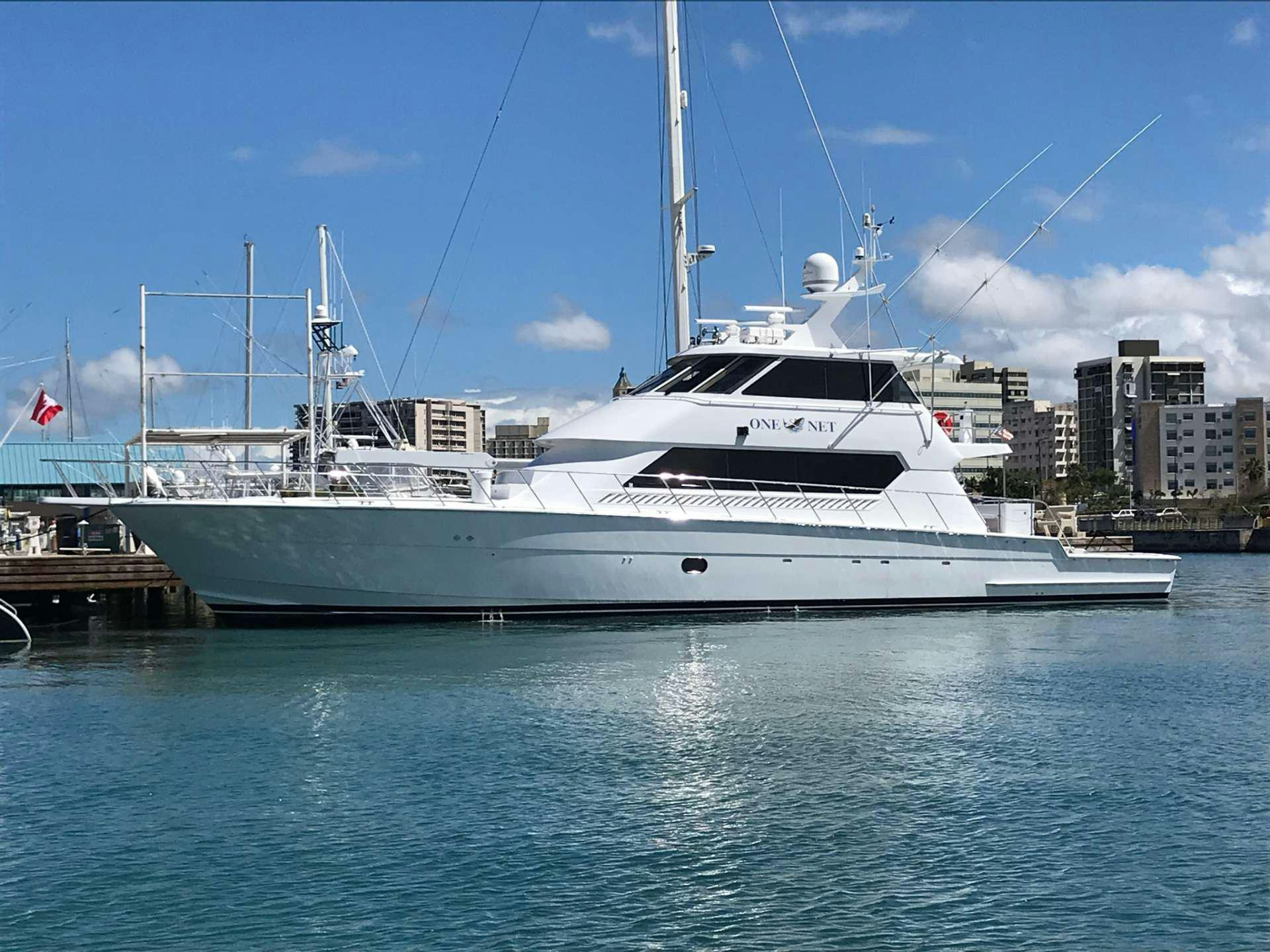 a large white boat in a harbor aboard ONE NET Yacht for Charter