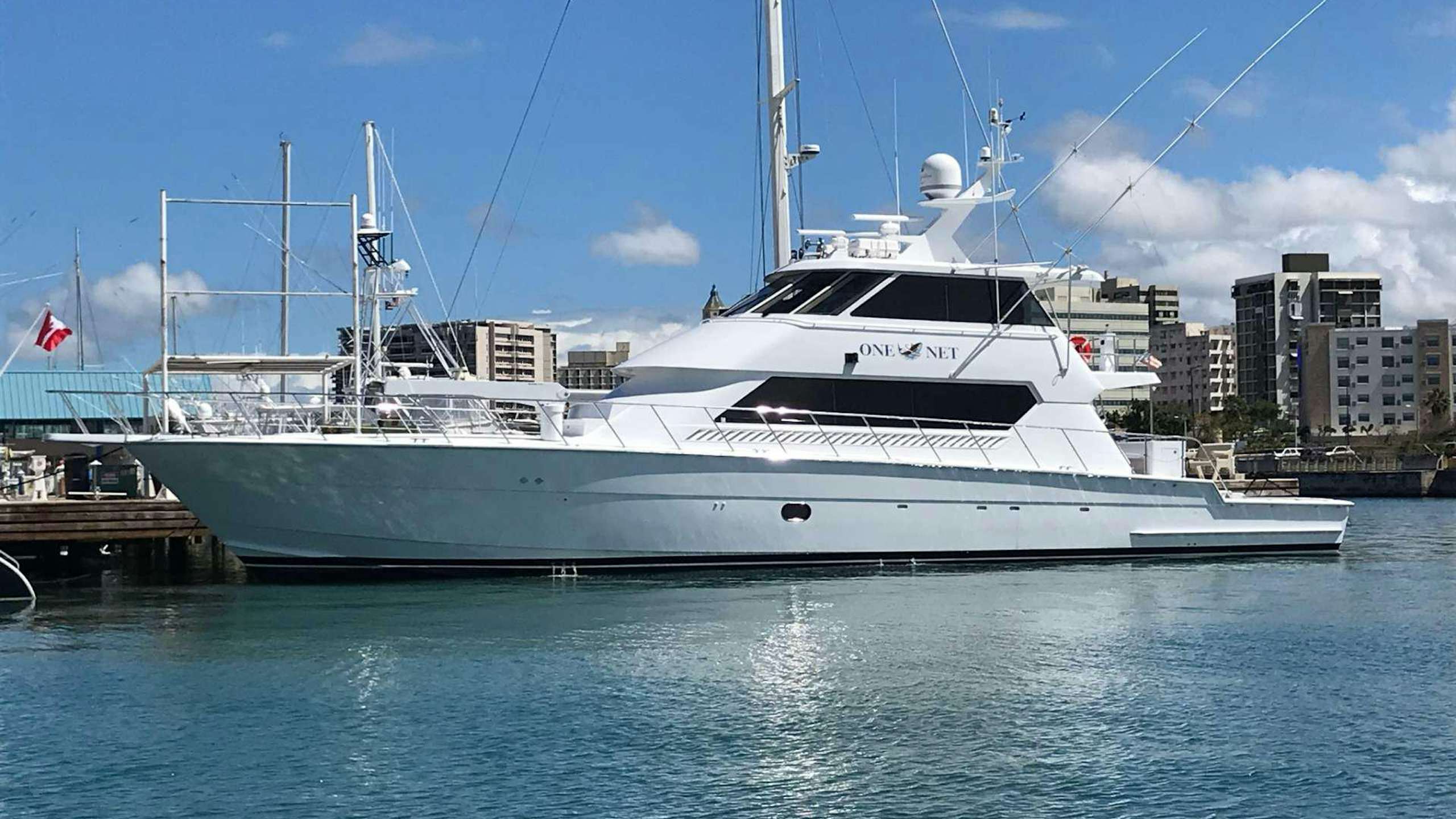 a large white boat in a harbor aboard ONE NET Yacht for Charter