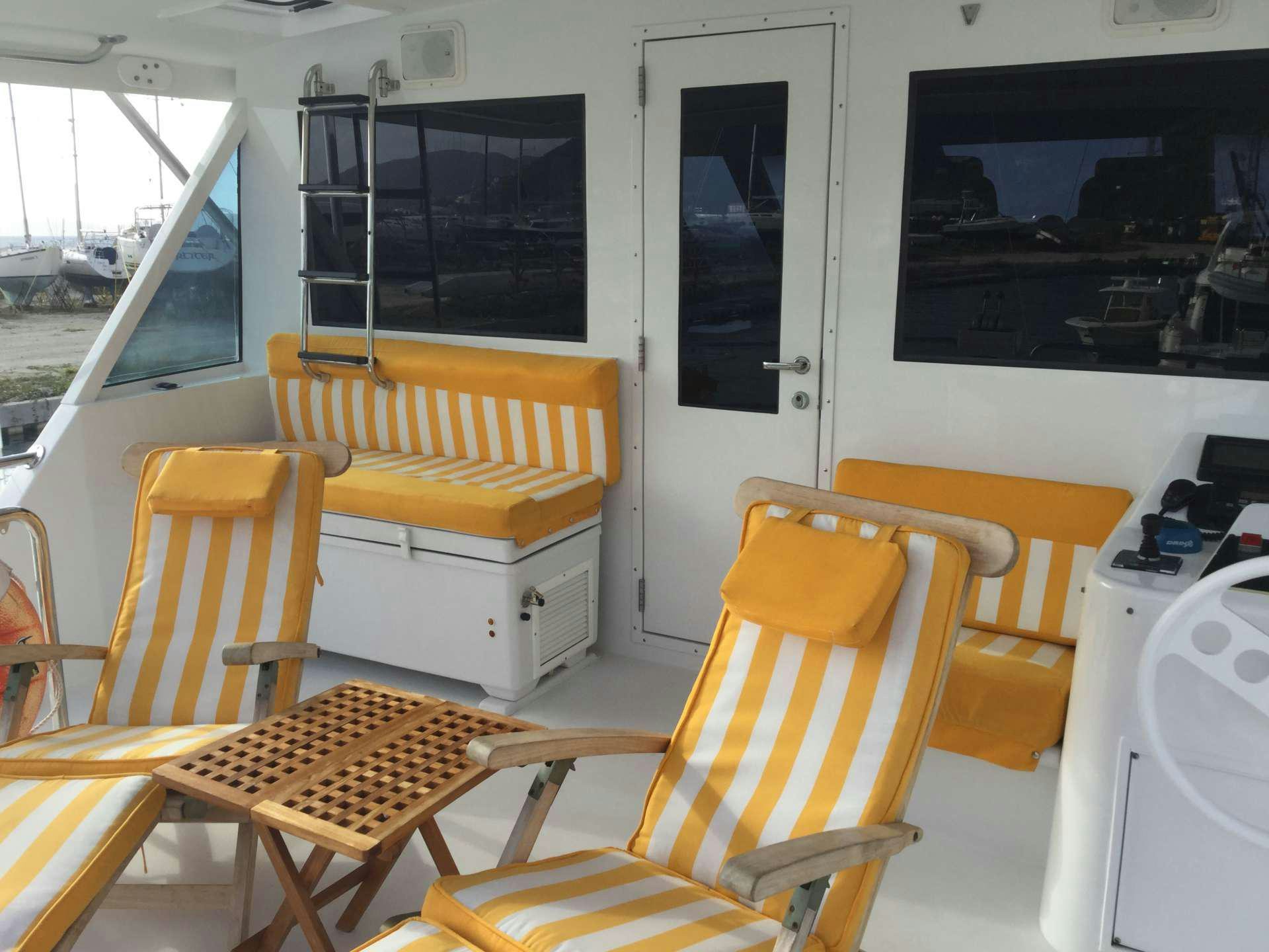 a room with chairs and a table aboard ONE NET Yacht for Charter