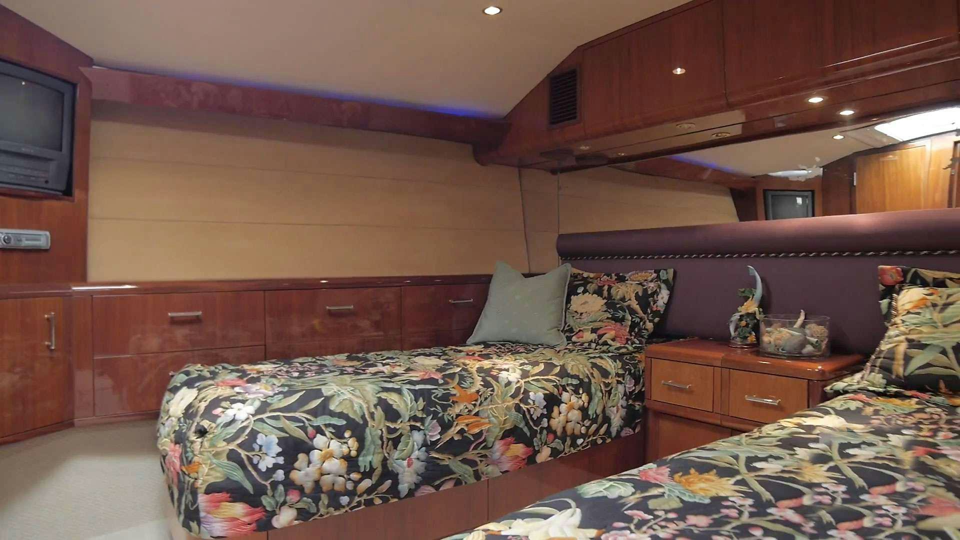 a bedroom with a bed and a television aboard ONE NET Yacht for Charter
