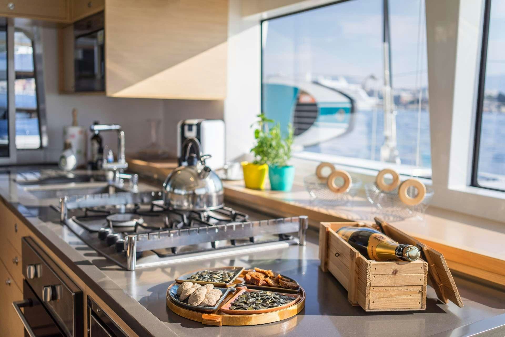 a kitchen with a stove and a window aboard Pura Vida Yacht for Charter