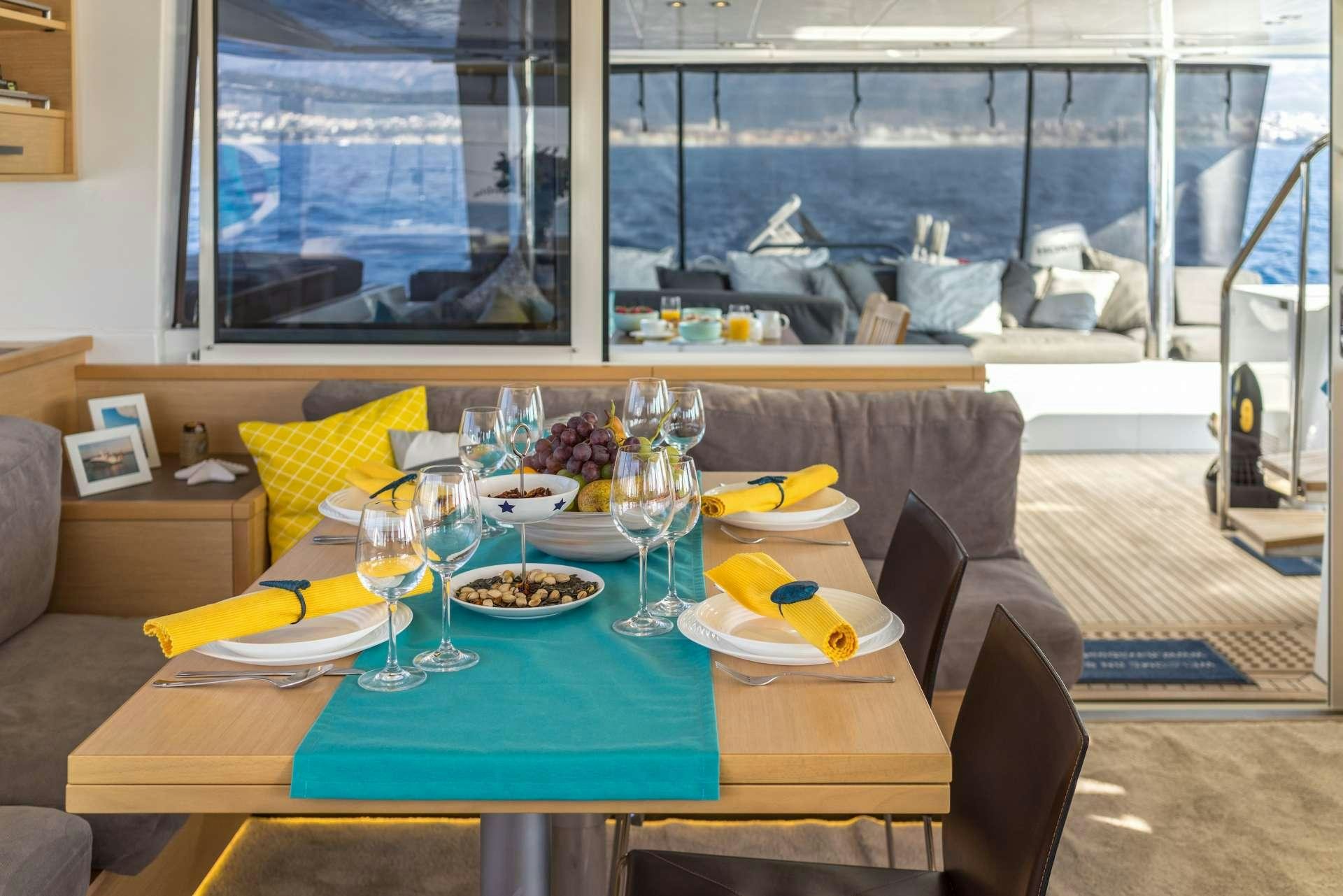 a table with food and glasses on it aboard Pura Vida Yacht for Charter