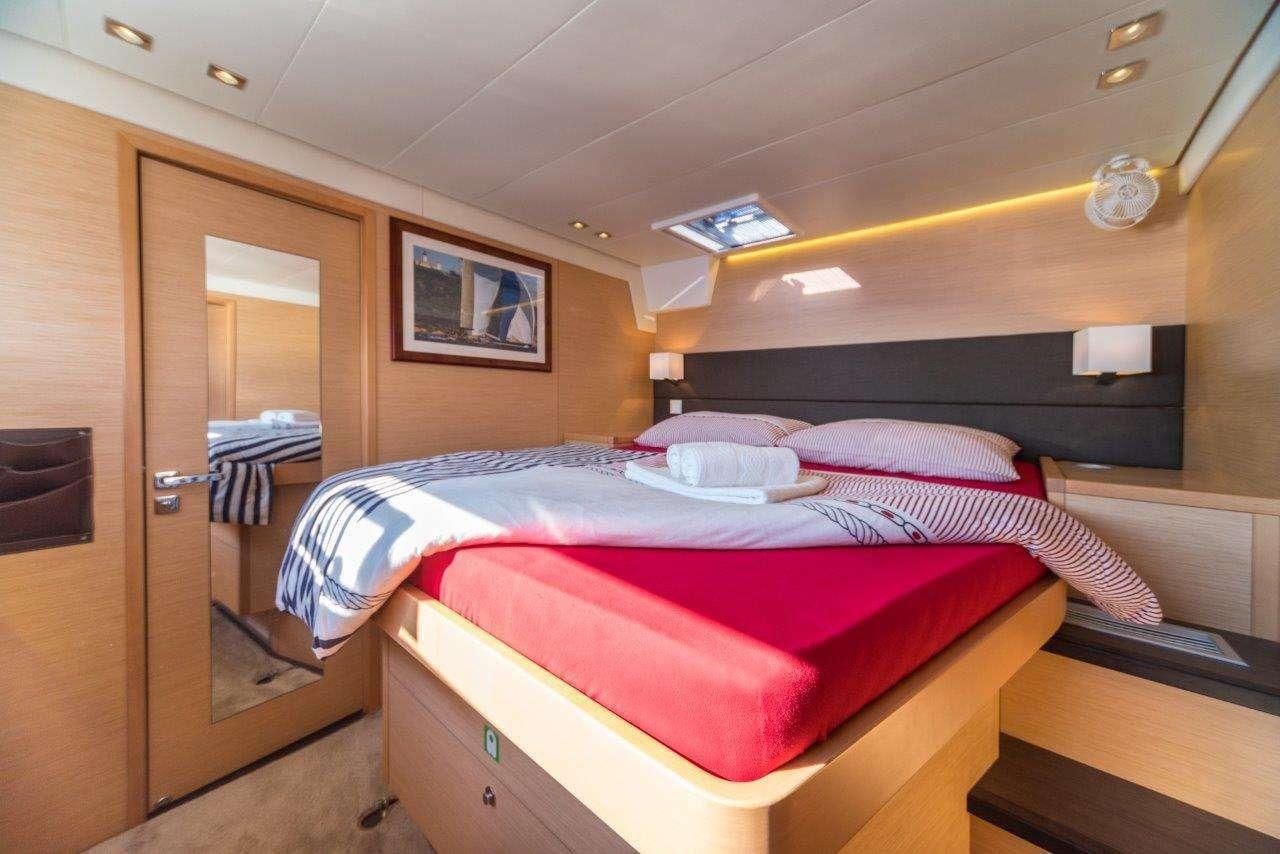 a bedroom with a bed and a closet aboard Pura Vida Yacht for Charter