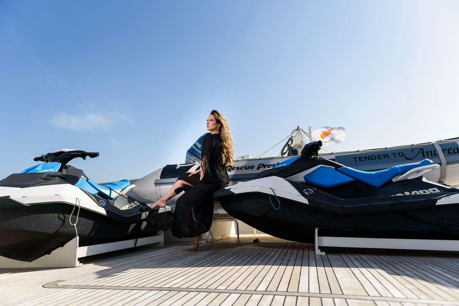 a person sitting on a deck next to several airplanes aboard LADY RINA Yacht for Charter