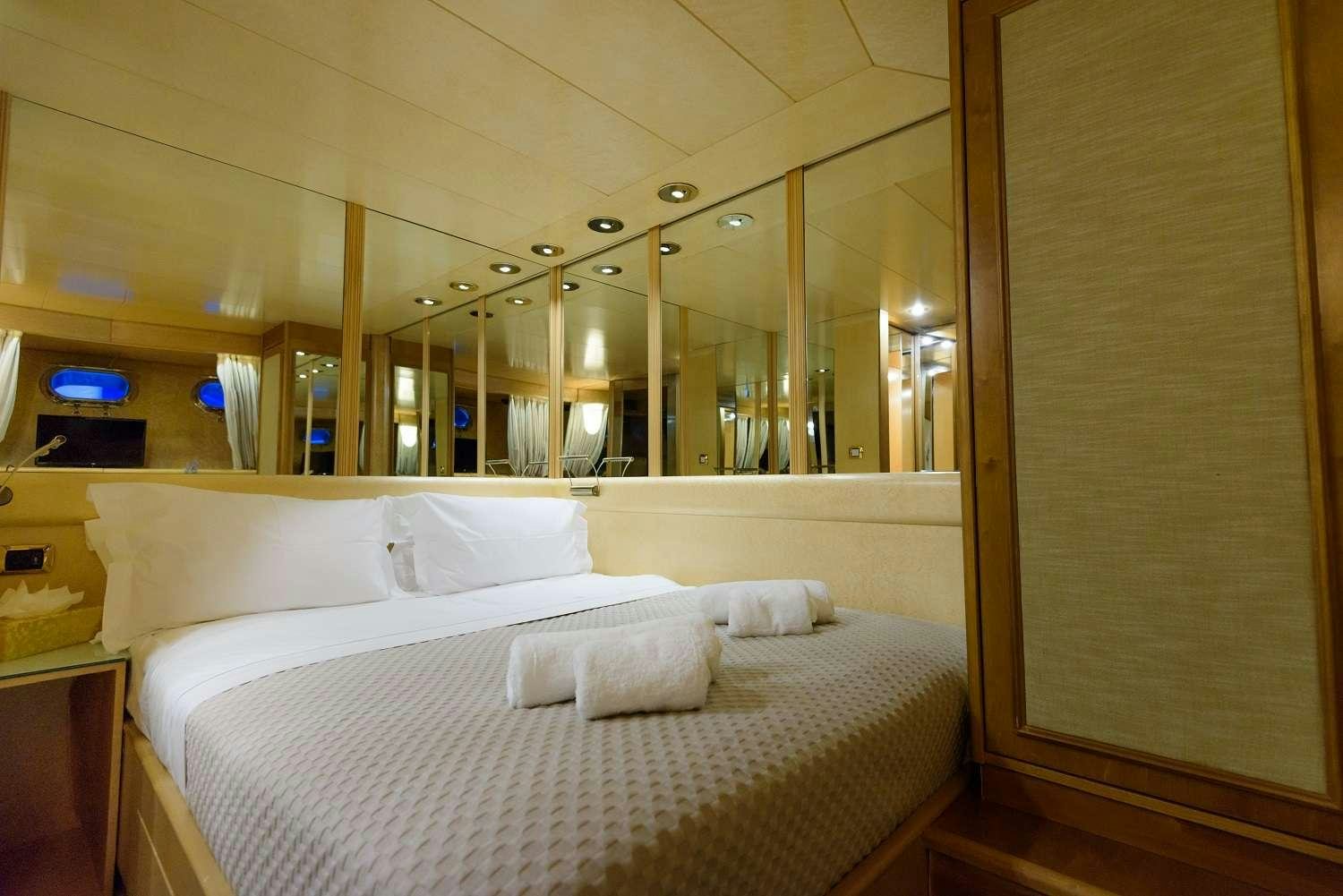 a room with a bed and a mirror aboard LADY RINA Yacht for Charter