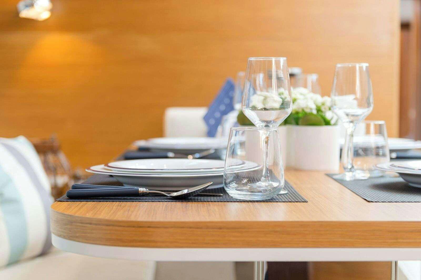 a table with plates and glasses on it aboard ALIZEE Yacht for Charter