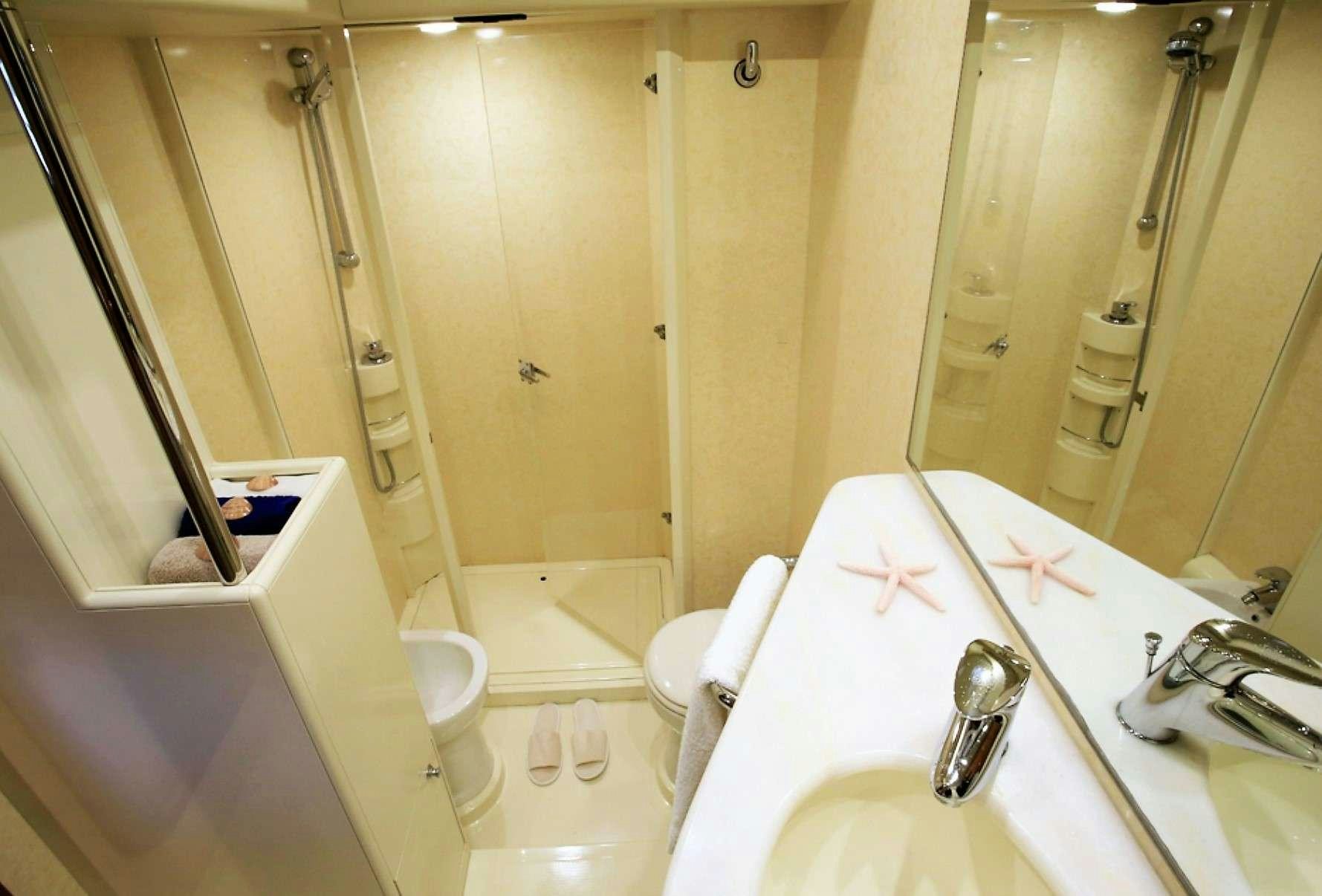 a bathroom with a bathtub sink and shower aboard ESPERANCE III Yacht for Charter